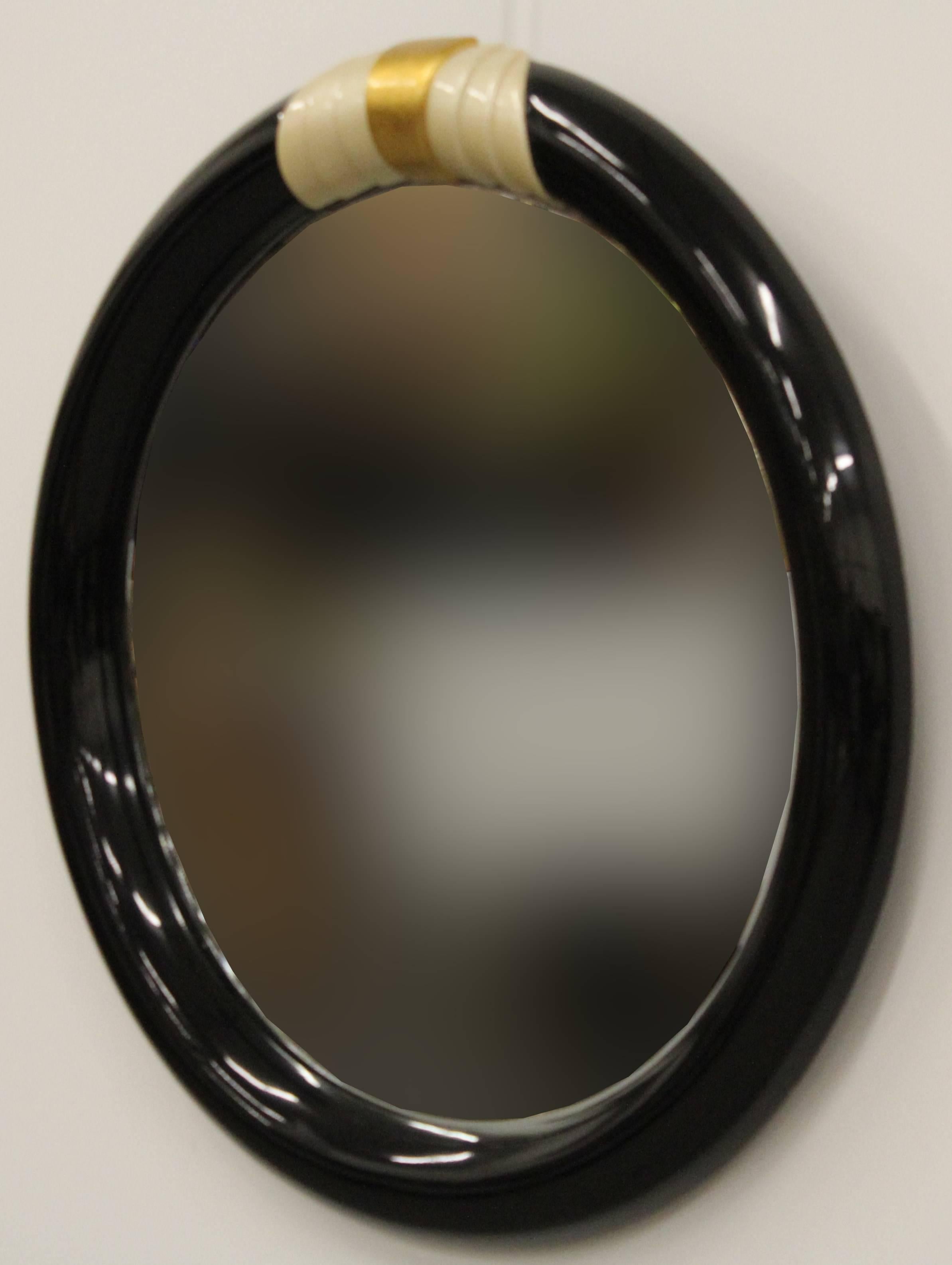 A beautiful glossy black Karl Springer style lacquered mirror with gold and ivory accents. Inset with 3/4