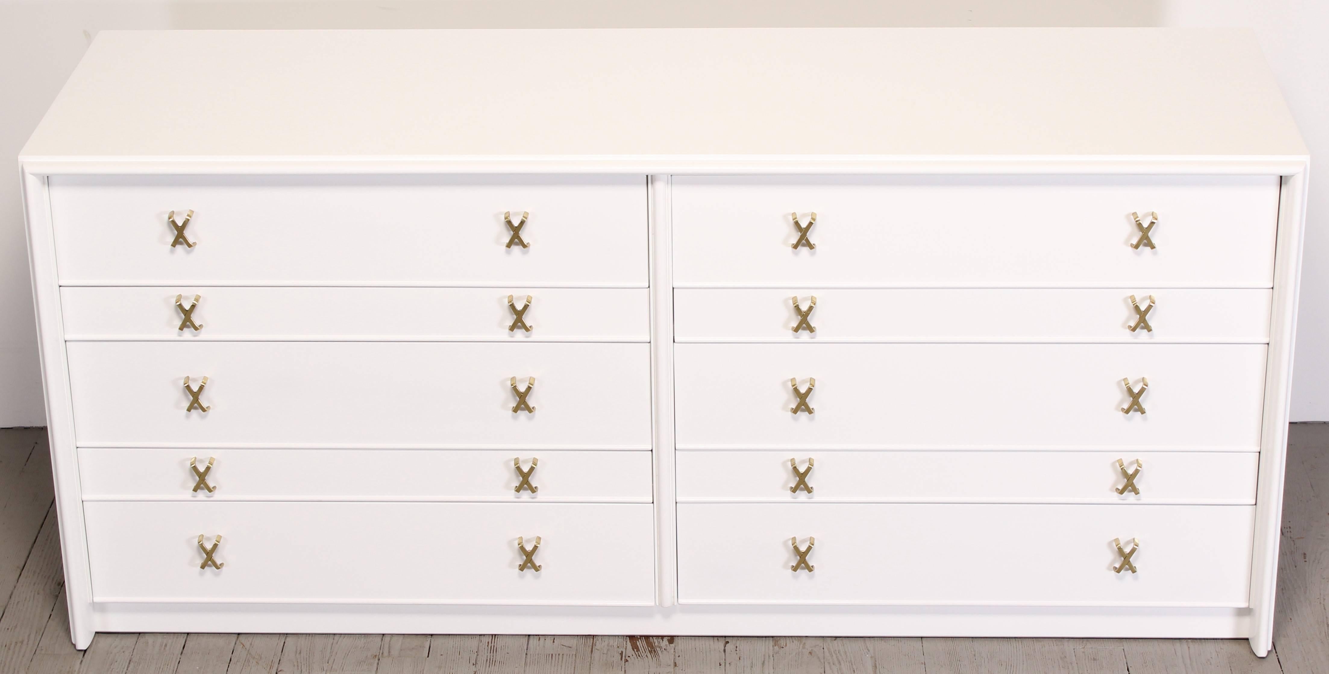 Ten-drawer dresser with brass X-pulls and white high gloss Italian finish by Paul Frankl. Newly refinished by Alternative Furnishings Inc. Matching nightstands available separately. See other listing. Labeled inside drawer Johnson Furniture Co.