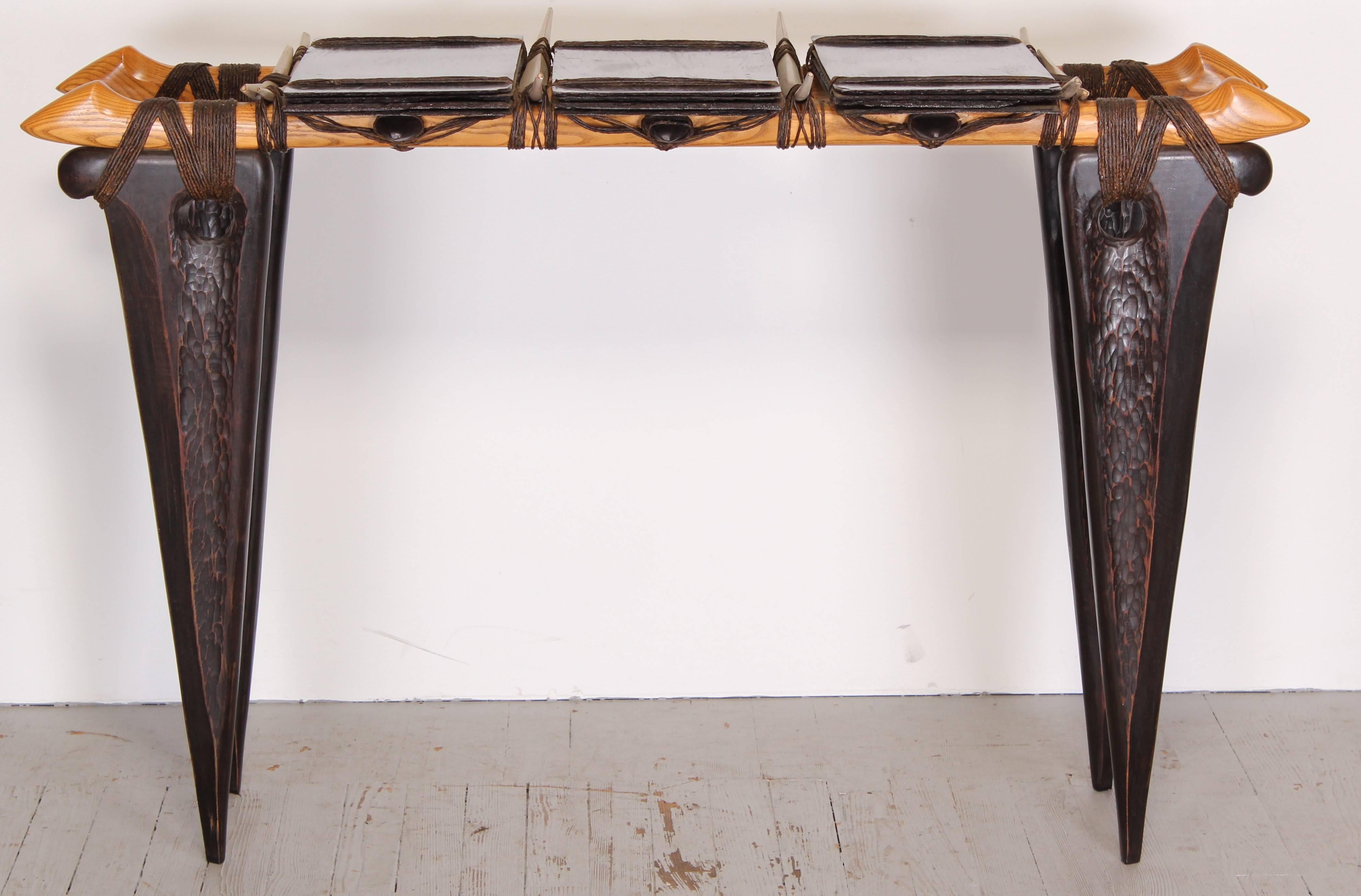 A hand-carved and chiseled bubinga and ebony wood console with wood roofing tiles, punctuated by oak spears, tied together with waxed jute. Keith Crowder's work was exhibited at the American Crafts Museum in New York in the 1980s.