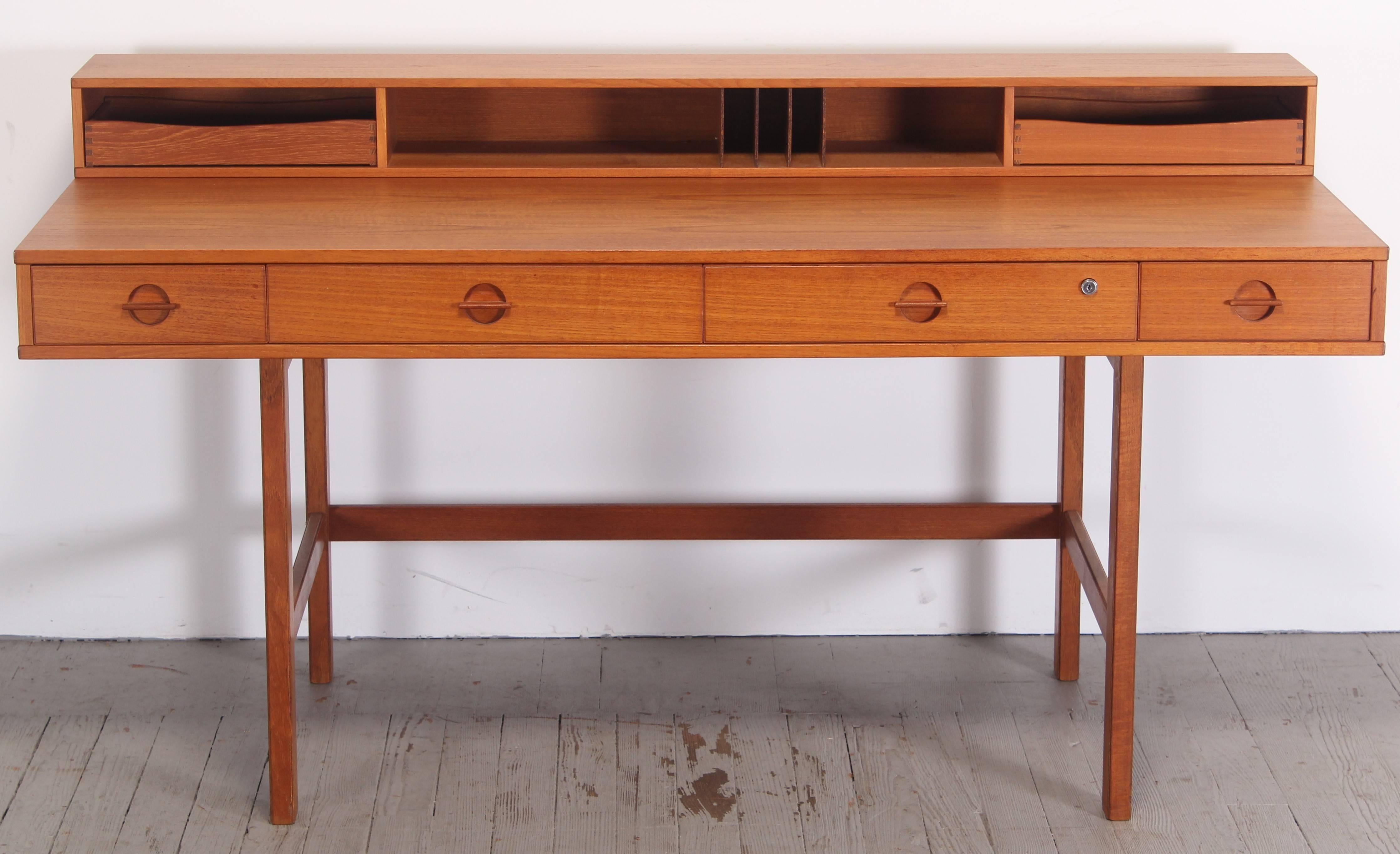 Designed by Peter Lovig-Nielsen, sometimes attributed to Jens Quistgaard. Excellent teak wood desk with four drawers, no key for lock, drawer is currently unlocked. Height of flip top up is 34", depth of desk is 38" when flip top is