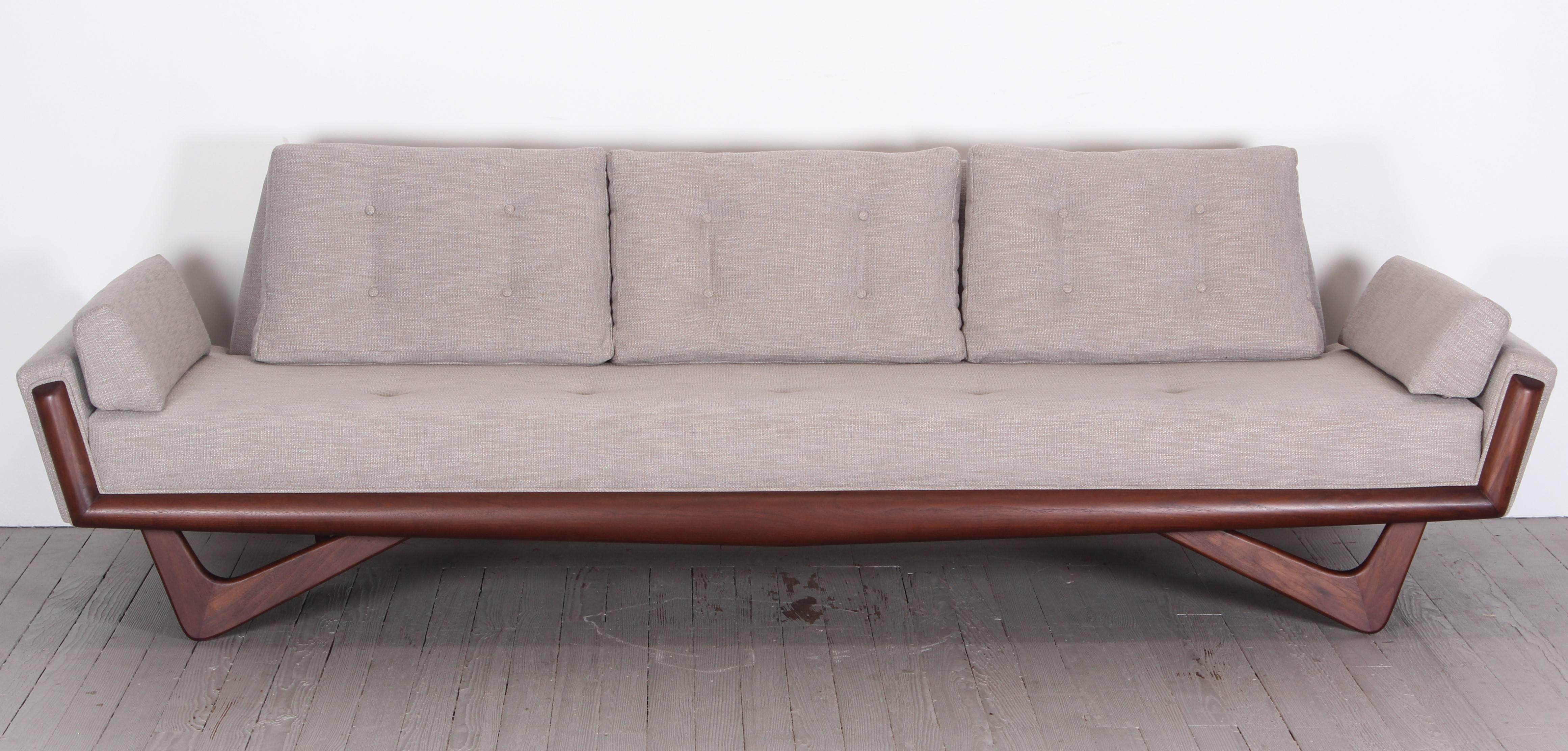 A refinished, reupholstered, Adrian Pearsall sofa with walnut trim and legs.