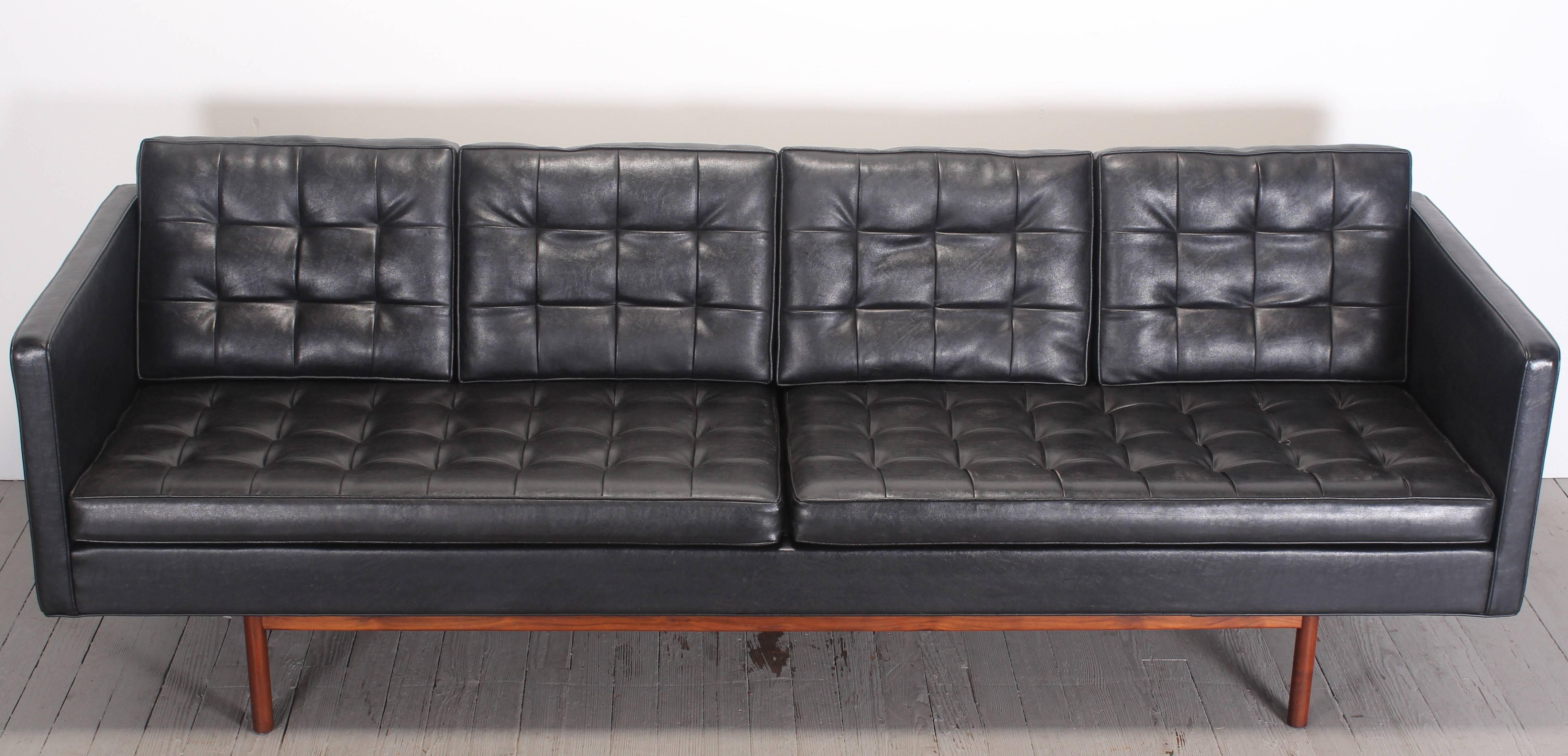 Original black vinyl upholstered Mid-Century Modern sofa designed Milo Baughman for Thayer Coggin in the Danish style. The walnut frame base retains original finish. A great example of American Modern.  Condition: The right seat cushion has several