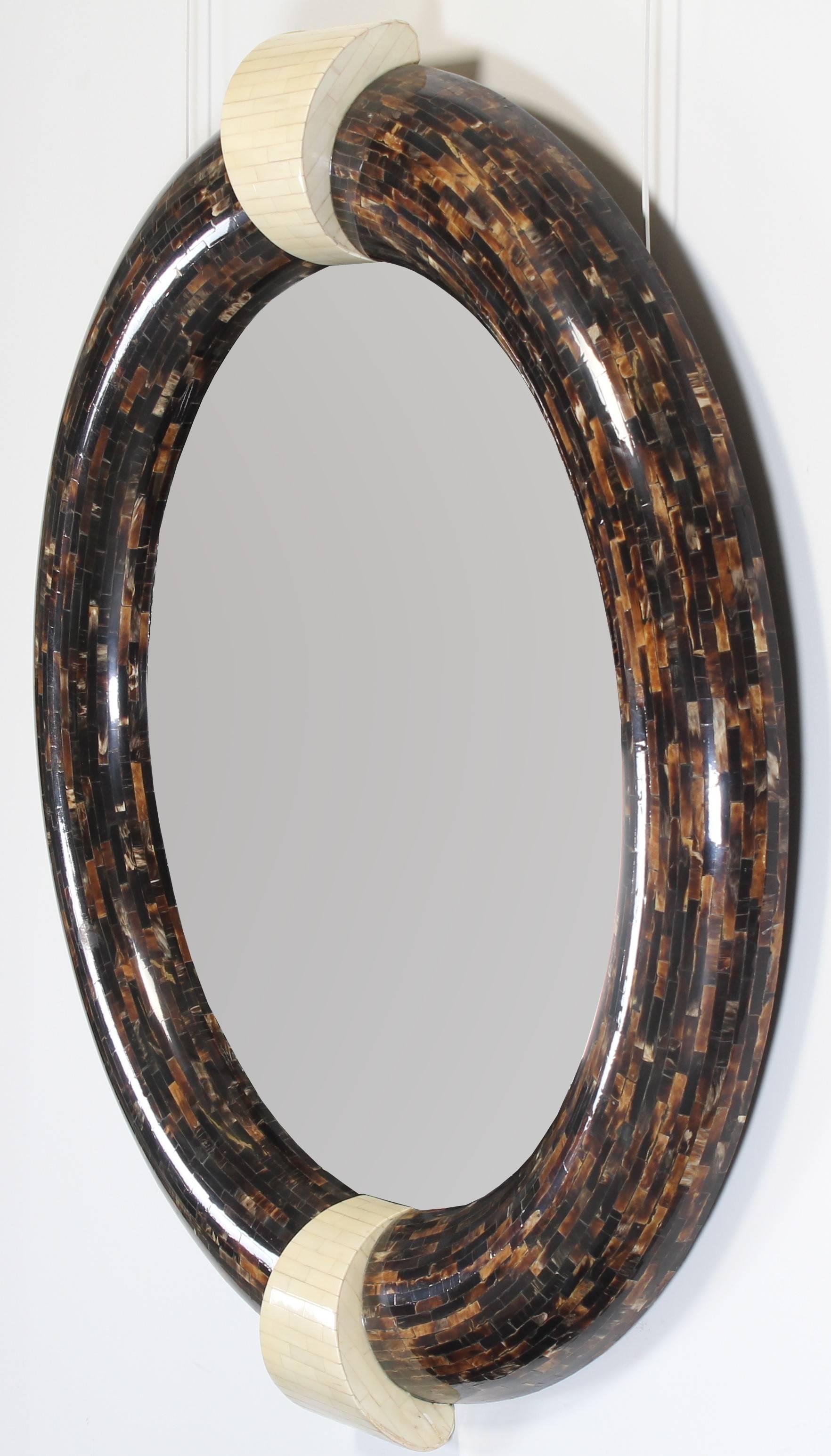 A unique tessellated bone and horn mirror in the manner of Enrique Garcel. Reminiscent of Karl Springer and Maitland-Smith. The keystones are tessellated in bone adding a unique accent to the tessellated horn frame. Stamped 'Made in Columbia' on