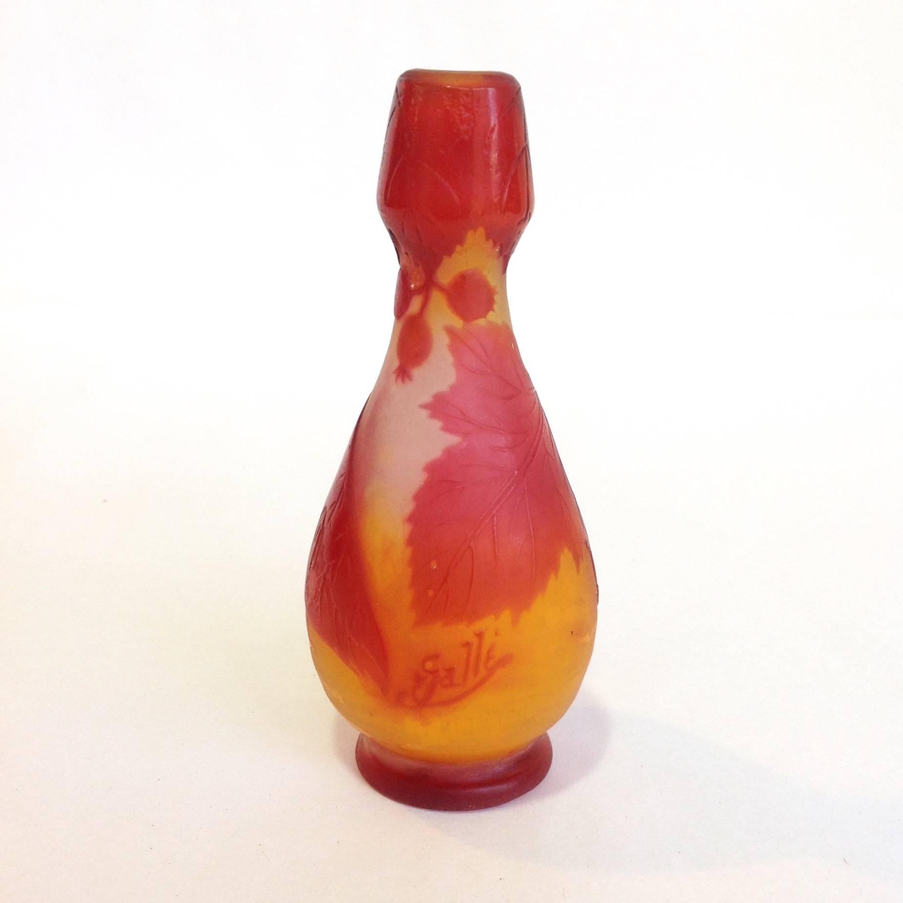 Petite red and yellow cameo glass vase made and signed by Emile Gallé (1846-1904). This 19th century Art Nouveau vase is decorated with leaves and berries. 