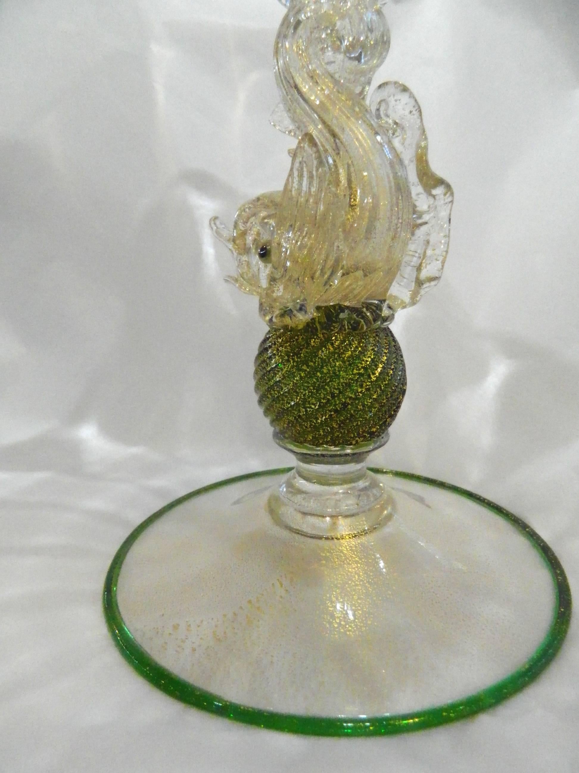 Venetian glass compote with a dolphin on a ribbed green and gold ball with fluted top and gold inclusions throughout. Italy,1970's.