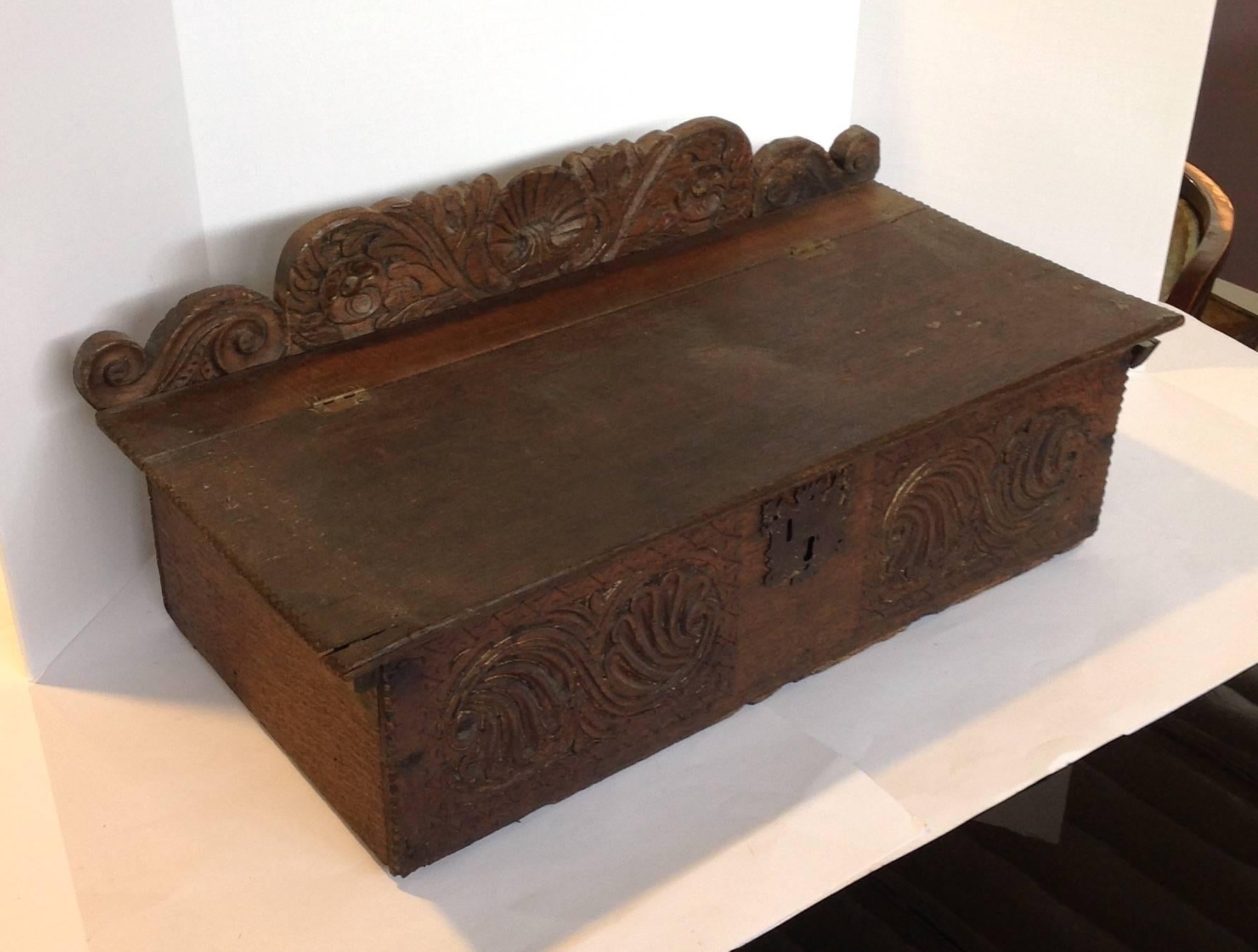 Antique English oak six board Bible box with carved front and back piece. The back is 11.25 inches high, to the lid is 7.75 inches high by 27 inches wide.
 