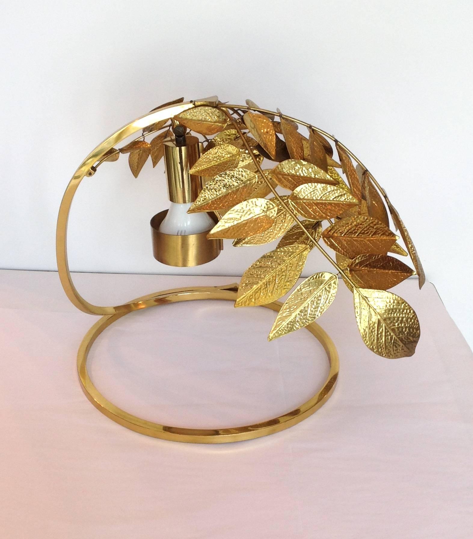 Vintage hammered brass leaves table lamp by Italian designer Tomasso Barbi. The leaves overhang the circular base, circa 1970s.