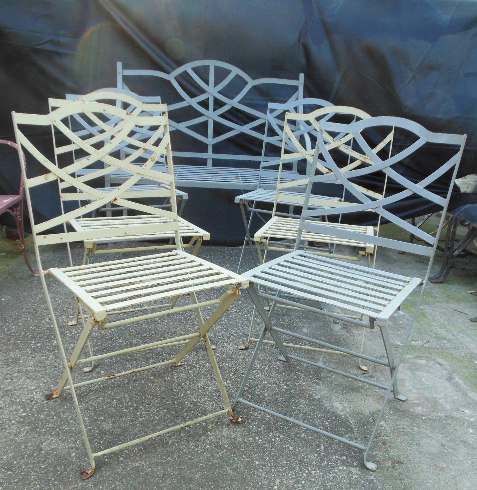 This is an unusual seven piece patio set with six bistro or folding chairs, en suite with a matching wrought iron bench. The chairs do fold as do bistro chairs. However, having a matching bench is unusual. Three of the chairs are gray in color &