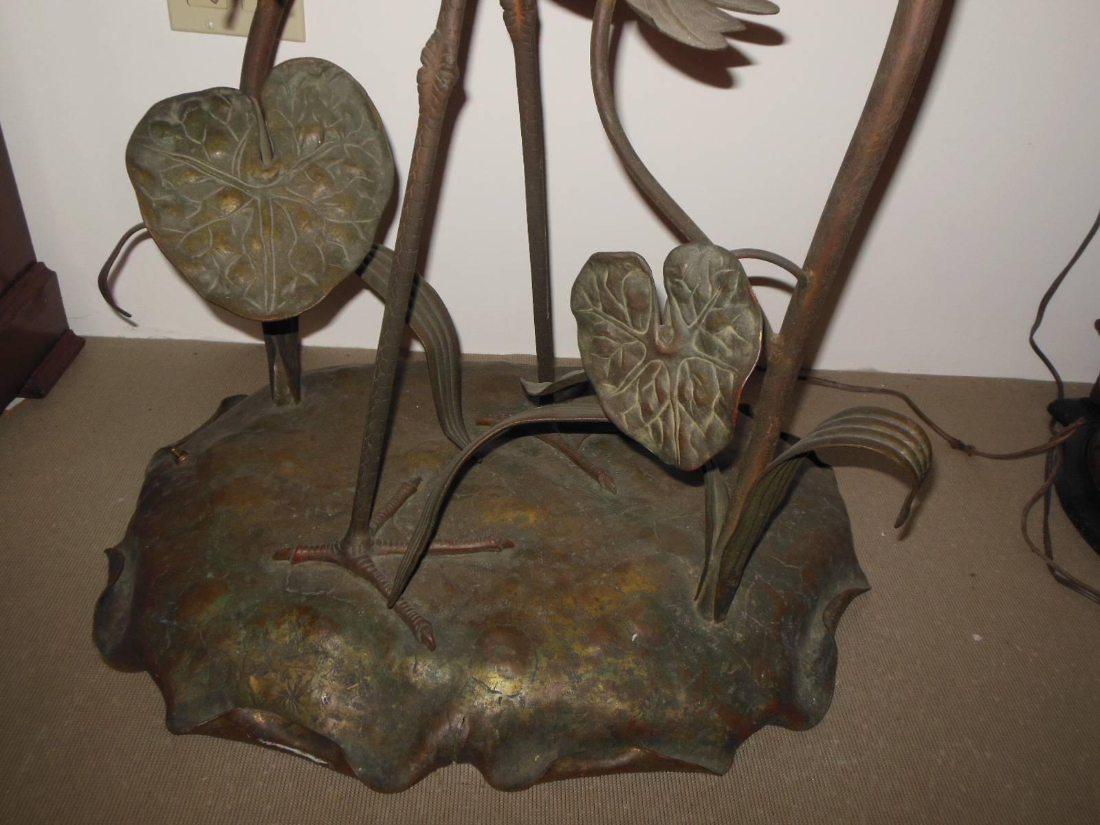 A Vienna Austrian bronze figural floor lamp with abalone shells, approximately 80" tall, with detail of a large full bodied egret in the marsh surrounded by large leaves, four of the leaves topped with abalone shells covering electrified light