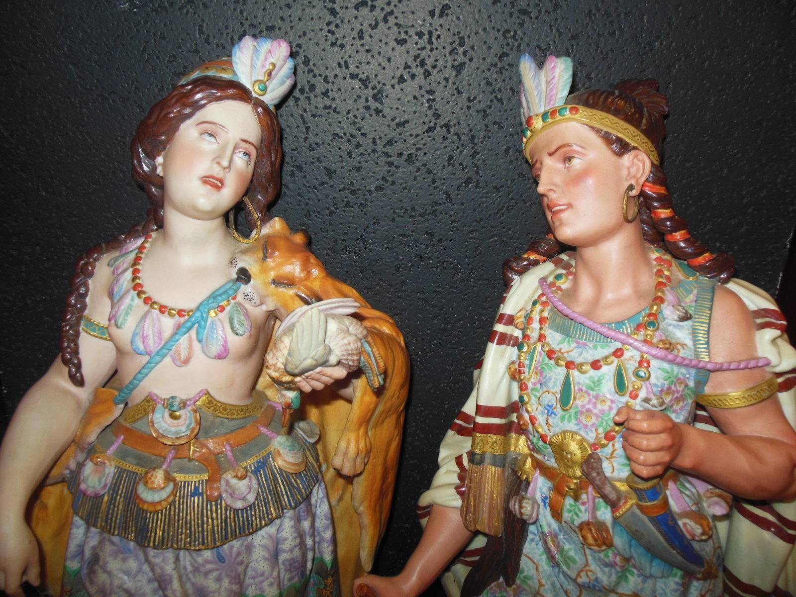 A monumental pair of Native American figurines wearing traditional Indian attire. The French biscuit figurines are colorful and masterfully painted. The condition though not mint is great for their age. The male figure is missing a dagger and the