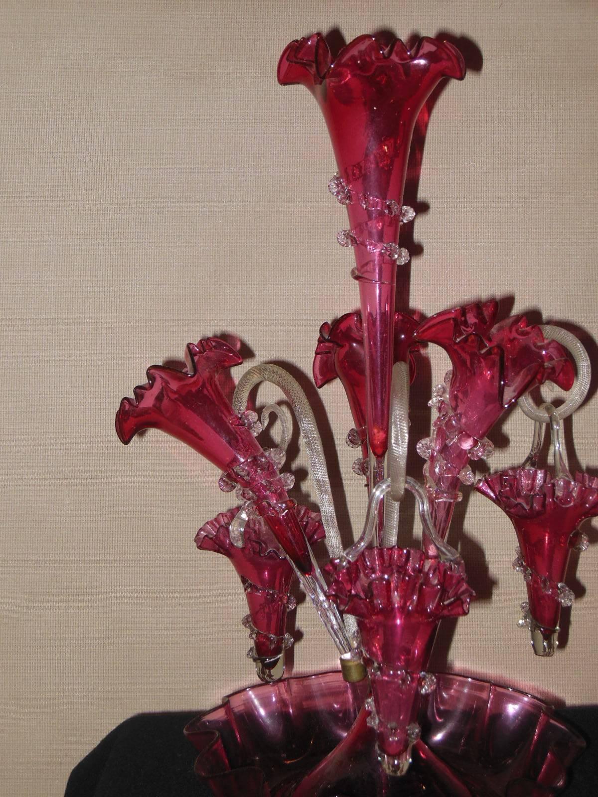 An English Victorian glass Epergne in excellent condition, this is the most desirable epergne as it has 3 hanging baskets and four vases approximate 16 inches tall. Epergnes of this quality were made in Stourbridge England in the late 19th century.