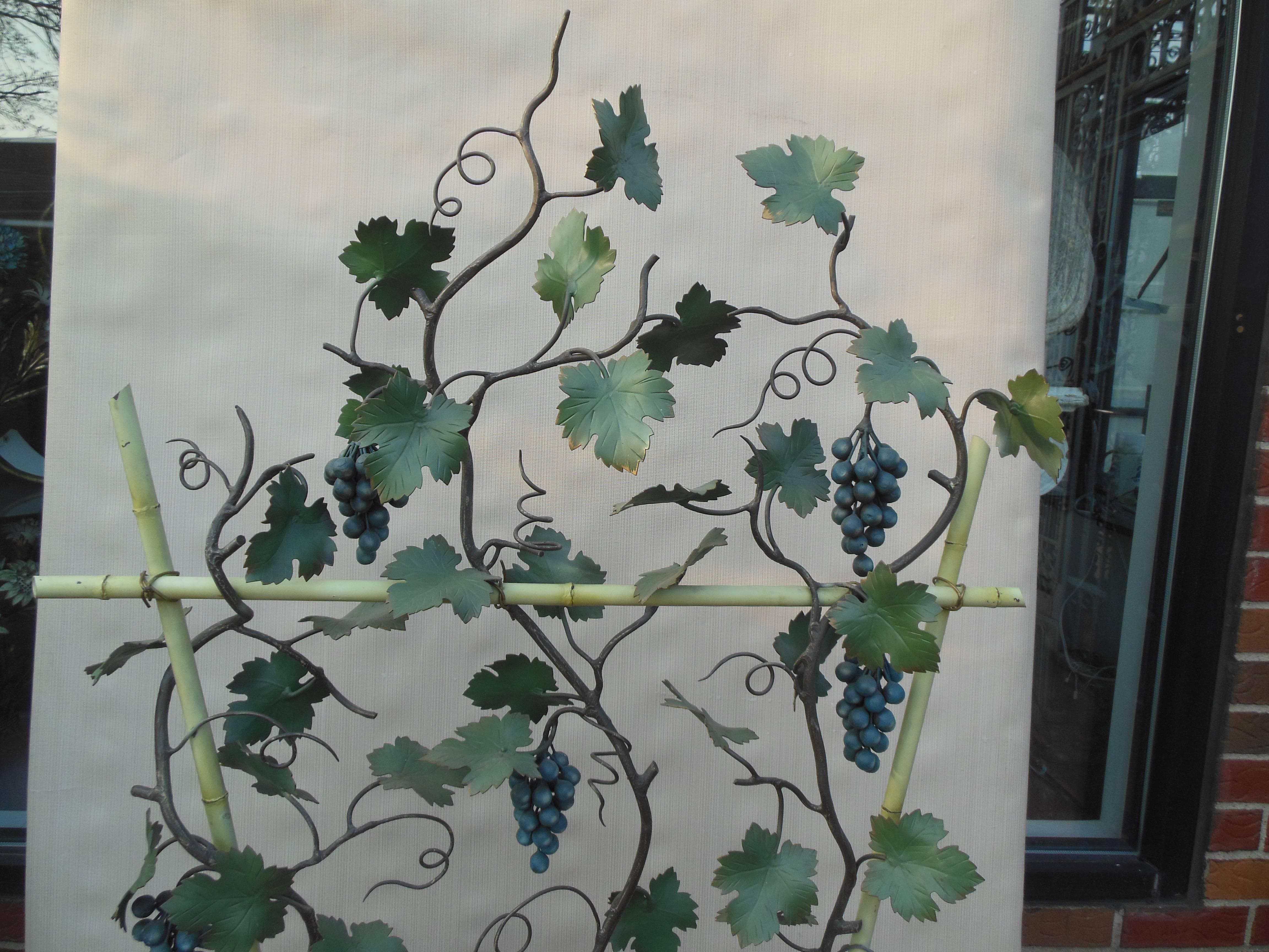 An Italian tole grape tree. The vintage tole tree in full bloom on both sides with multiple bunches of life like blue grapes in between the green leaves. The condition for this vintage item is excellent and large tole items do not appear frequently.