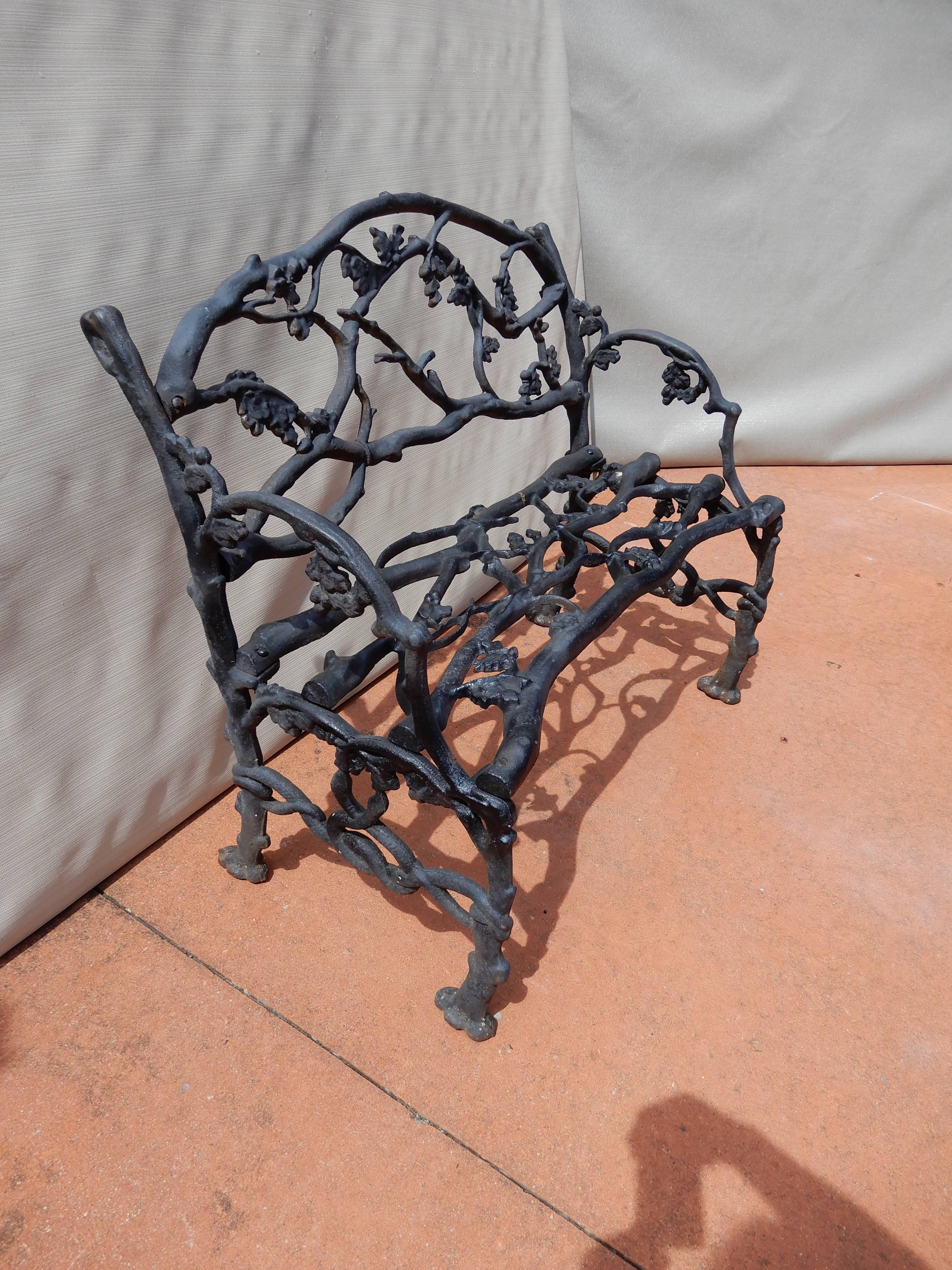 Cast iron garden bench in the naturalistic twig or Rustic pattern. Usually these Benches appear in the longer size but this bench is only 33 inches long. The bench is adorned with details of oak leaves, acorns and snakes on the arms. The Rustic or
