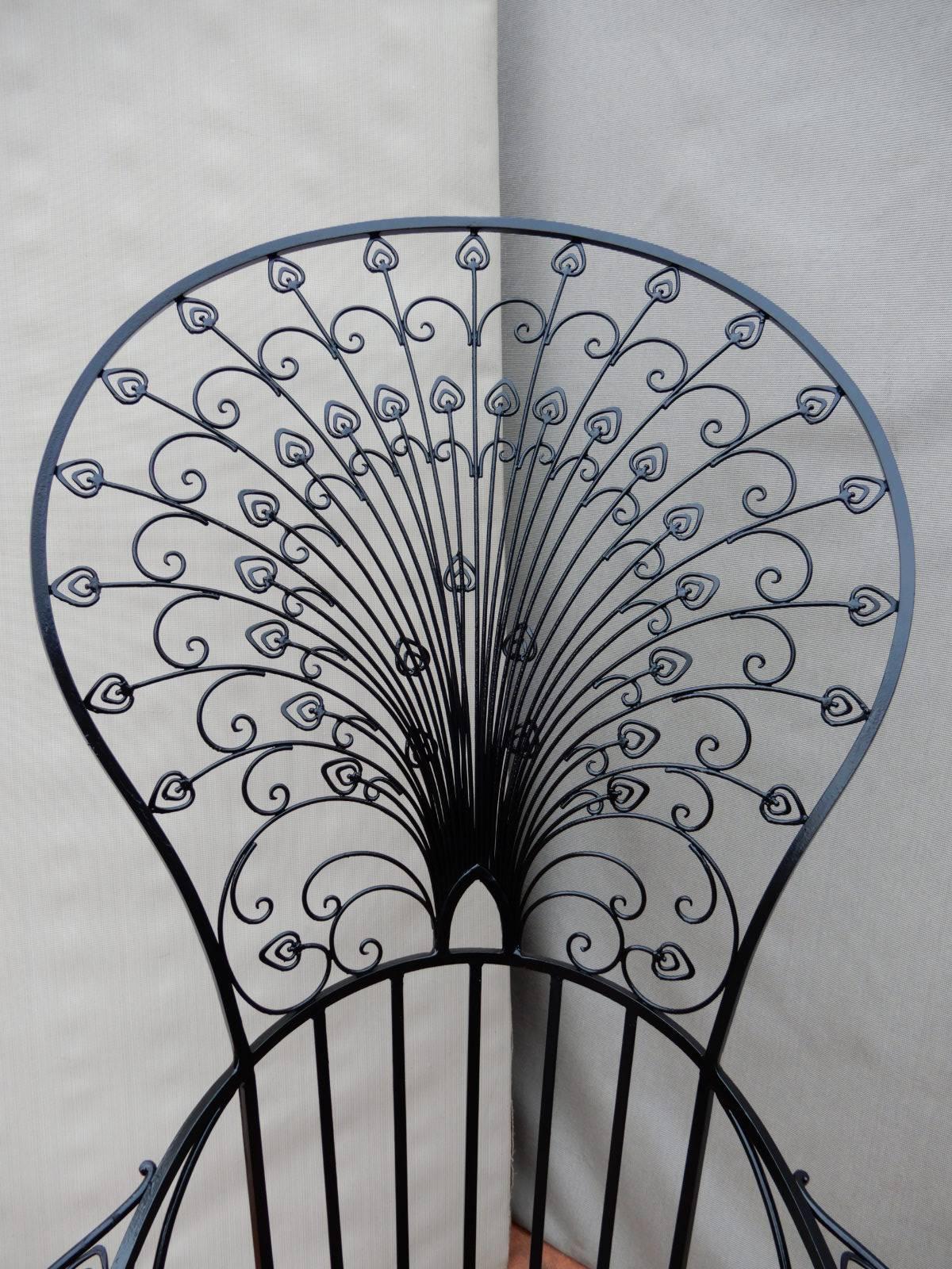 An ornate wrought iron peacock chair. A recently discovered ad shows the chair to be made by Florentine Craft Studio chief competitors to Salterini. The peacock chair has just been sandblasted and painted black. It is in excellent condition.