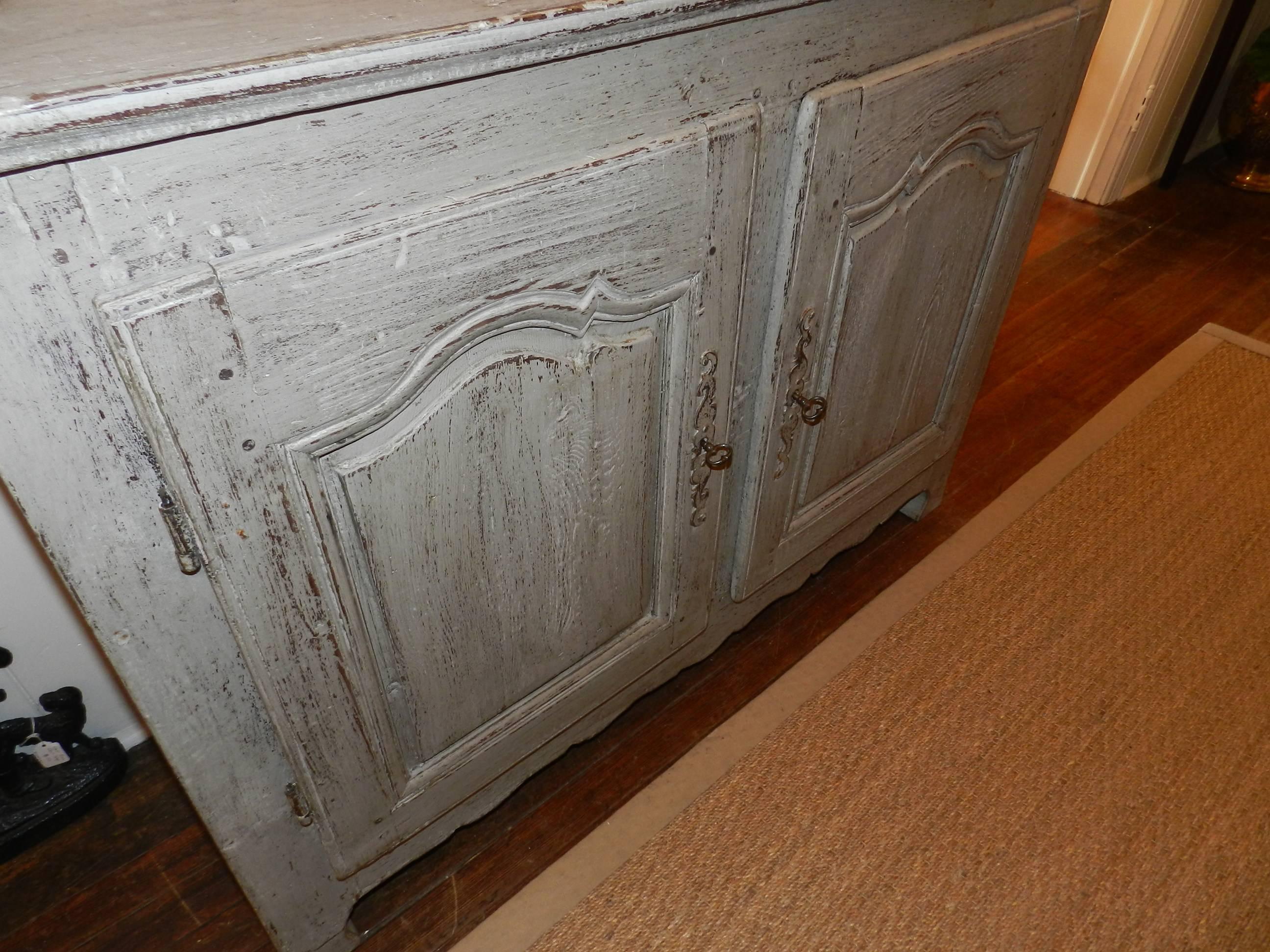 French oak cabinet with two-panel doors and worn grey paint.