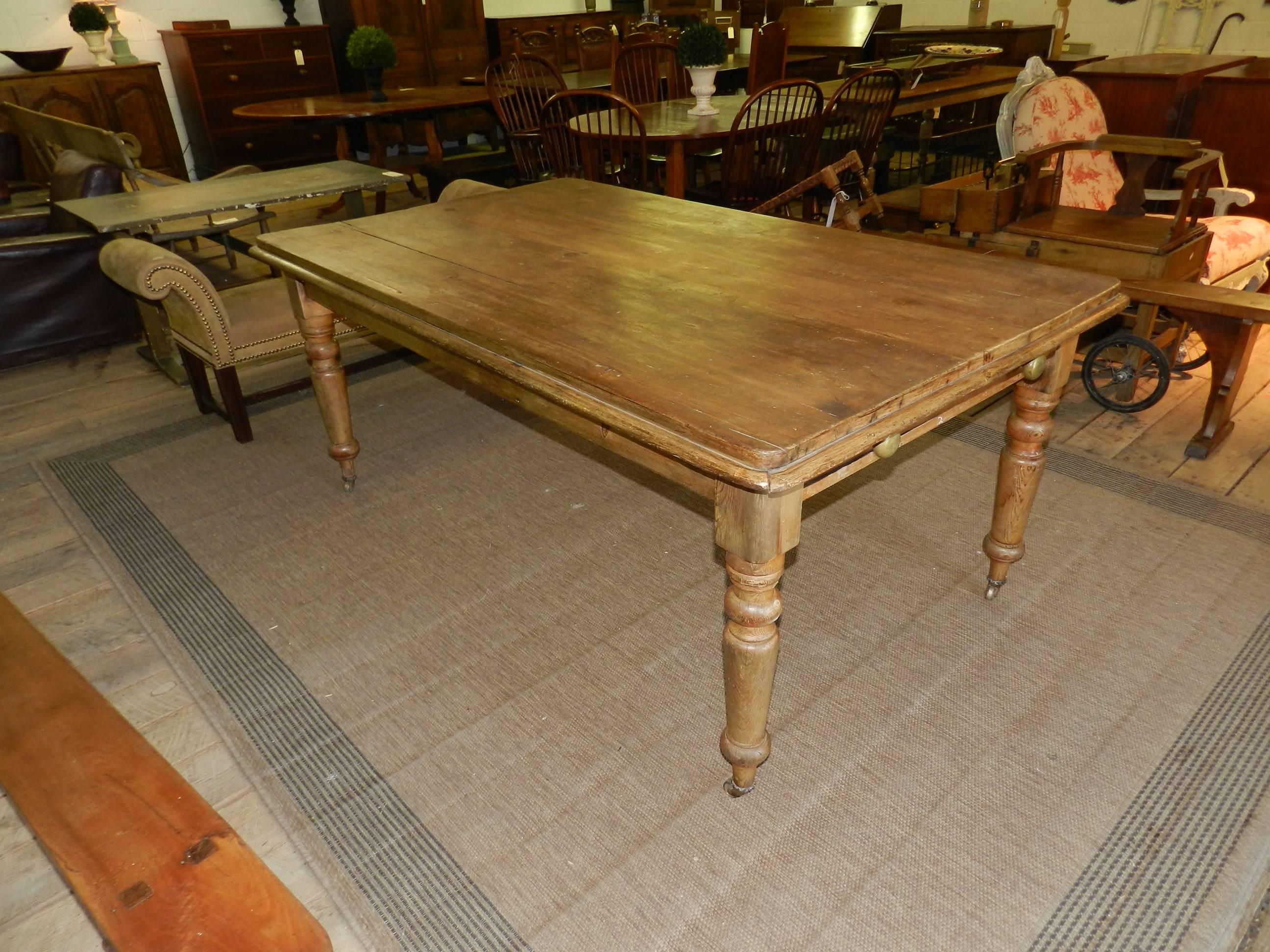 Scottish antique pine farm table with turned legs and drawer with brass knobs.