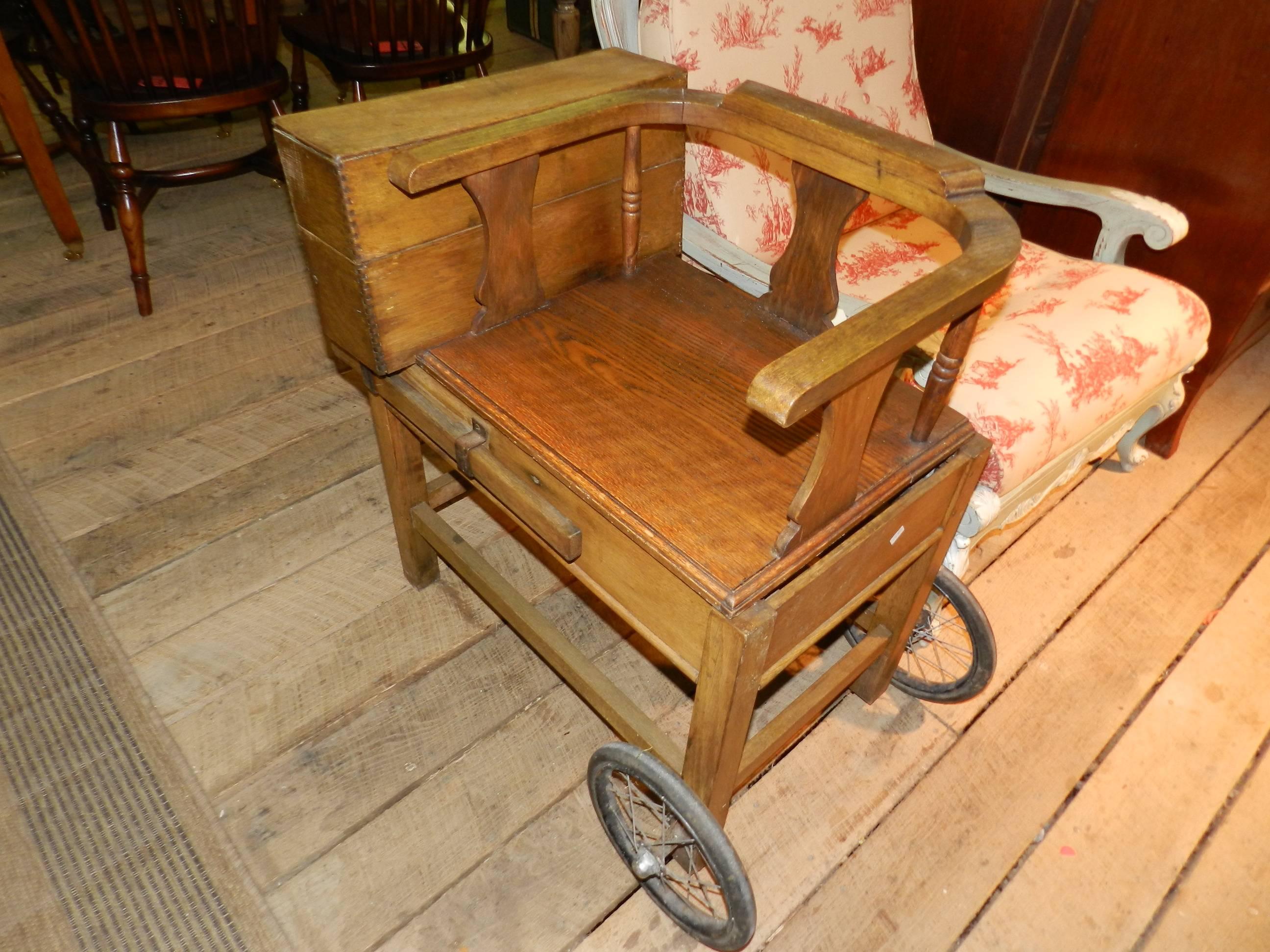Antique oak jockey weighting scales with brass and iron scales, two extendable handles and two wheels.