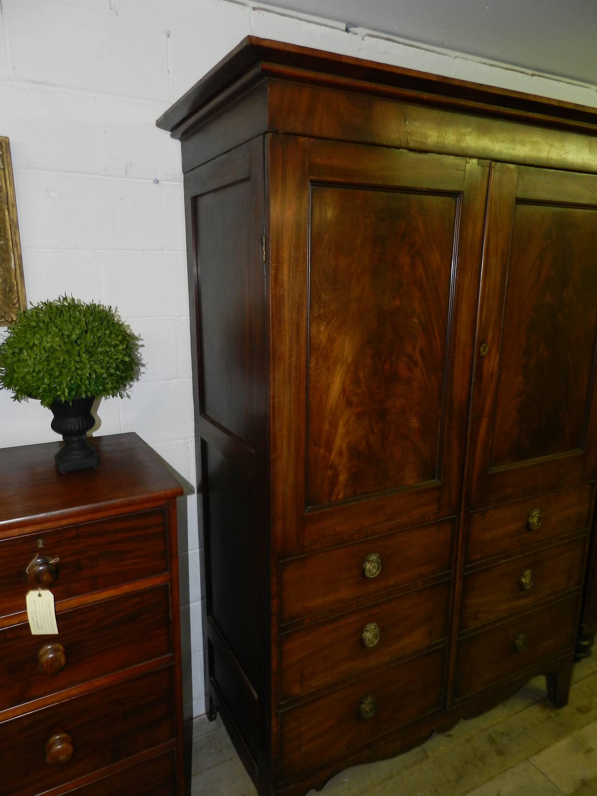 Irish mahogany two-door armoire made to look like a six-drawer linen press with paneled sides and hanging rail. This piece can be taken apart for moving.