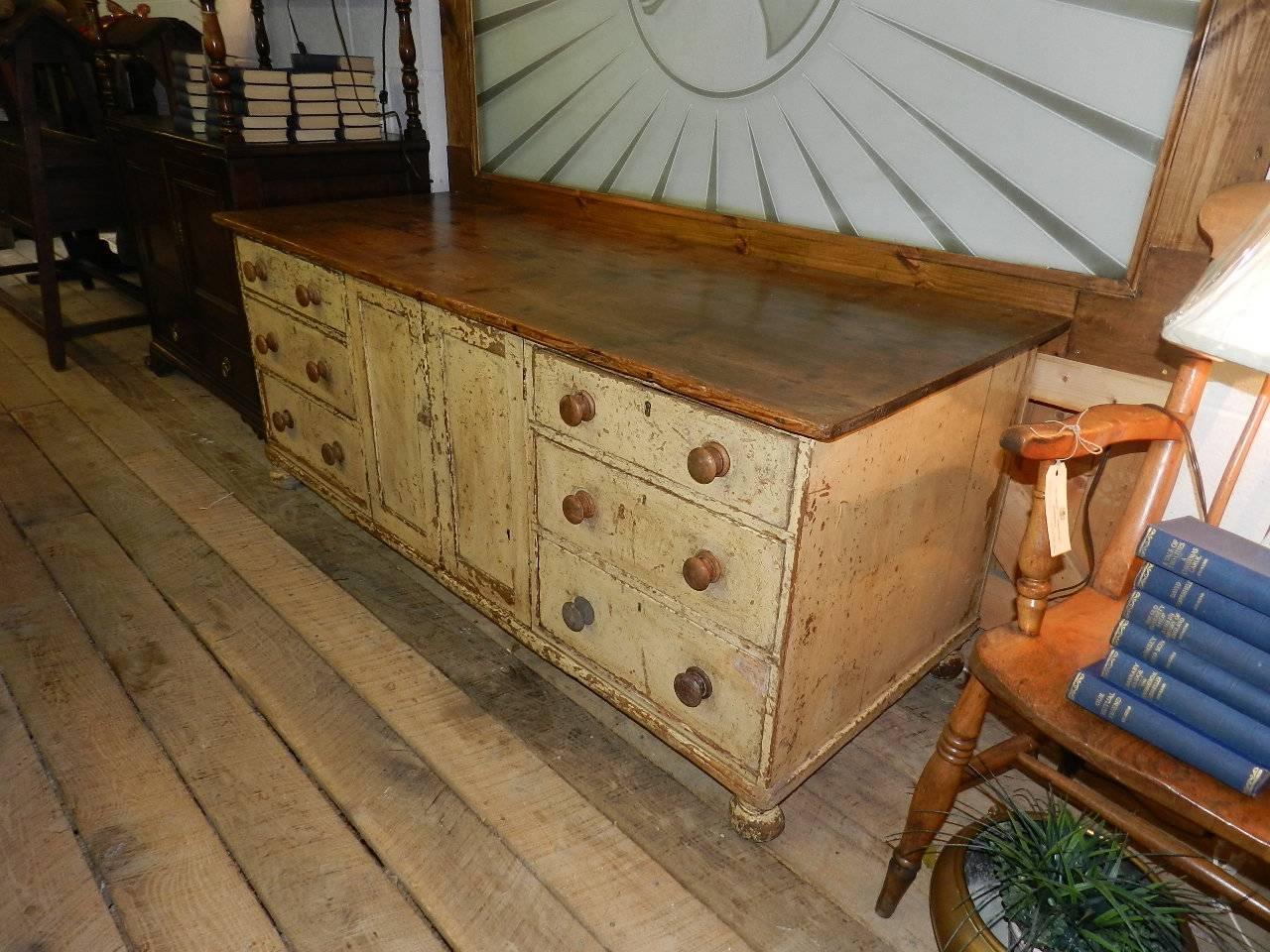 Antique pine dresser from East Yorkshire in England .The drawers have dovetailed joints and wooden knobs. The central cupboard has a pair of paneled doors.The paint is original .