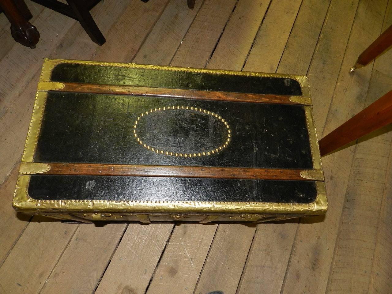 French brass bound shipping trunk with brass locks and oak strapping. The interior has a lift out tray and document sleeve.