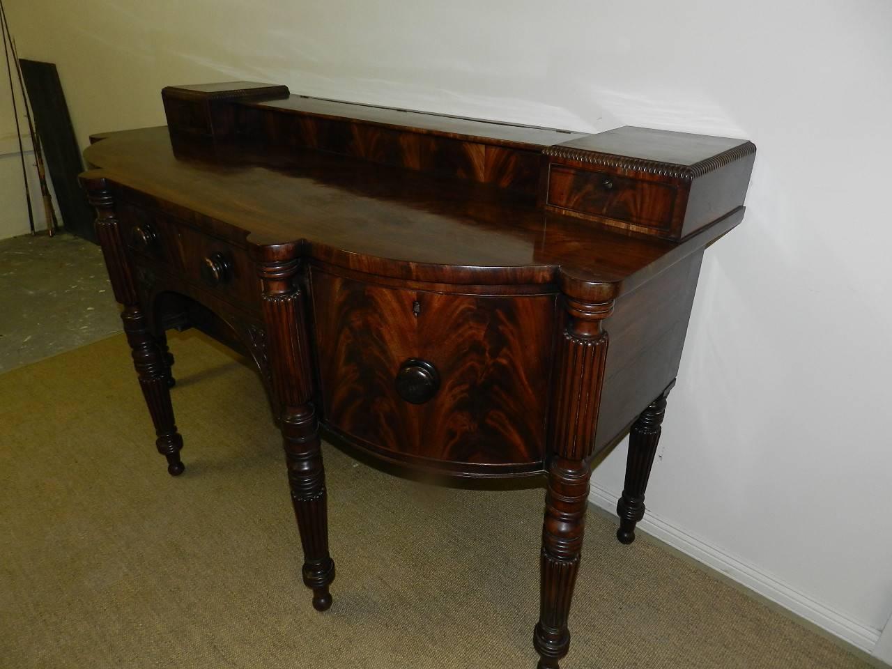 Stunning Scottish mahogany sideboard .Two central drawers, a deep wine drawer on the right and a cupboard on the left all have original knobs. The stage back has a baize lined lidded central cutlery storage area flanked by two small drawers. The