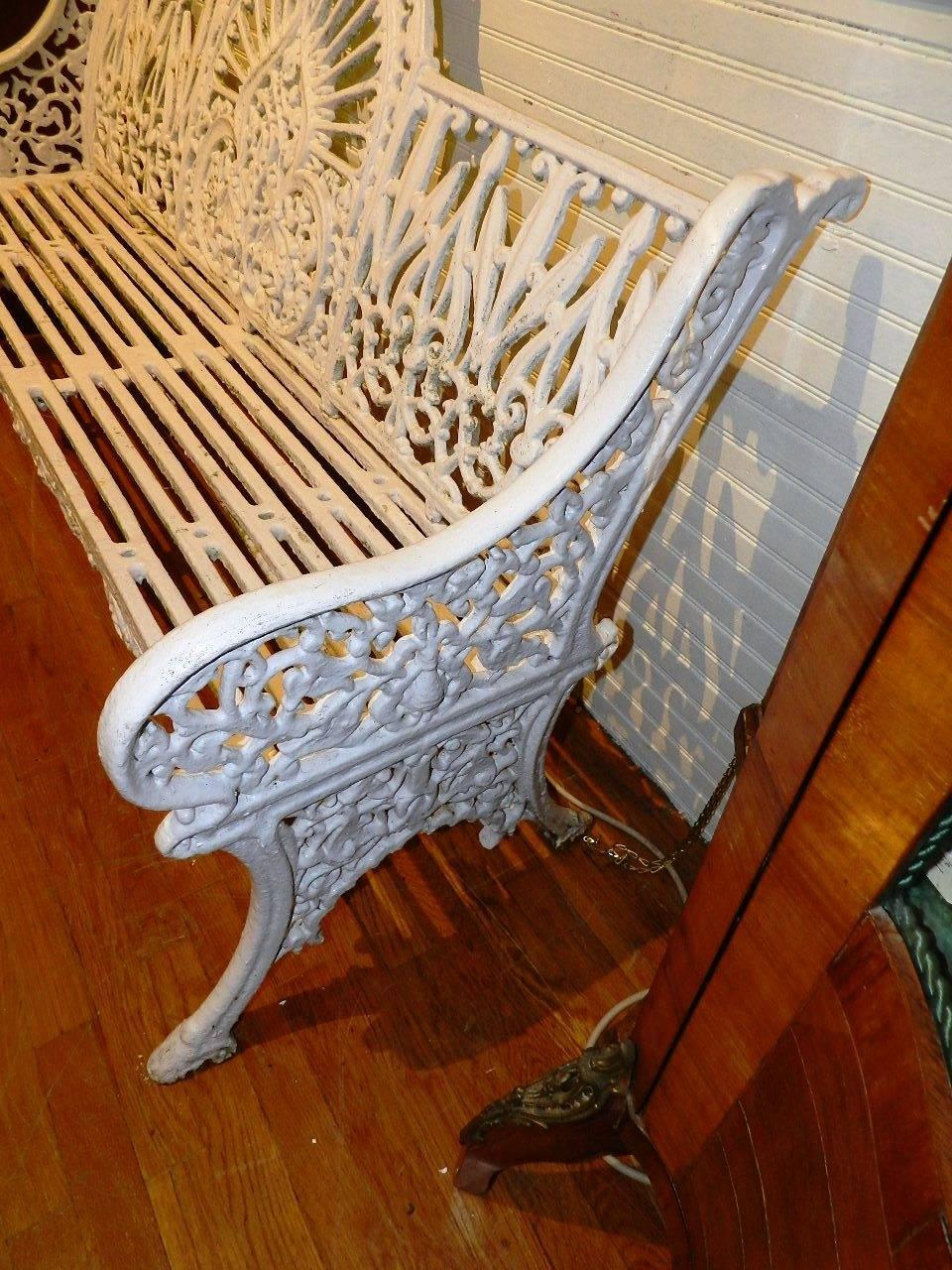 Original cast iron Coalbrookdale garden bench with the peacock pattern back and hoof like feet.