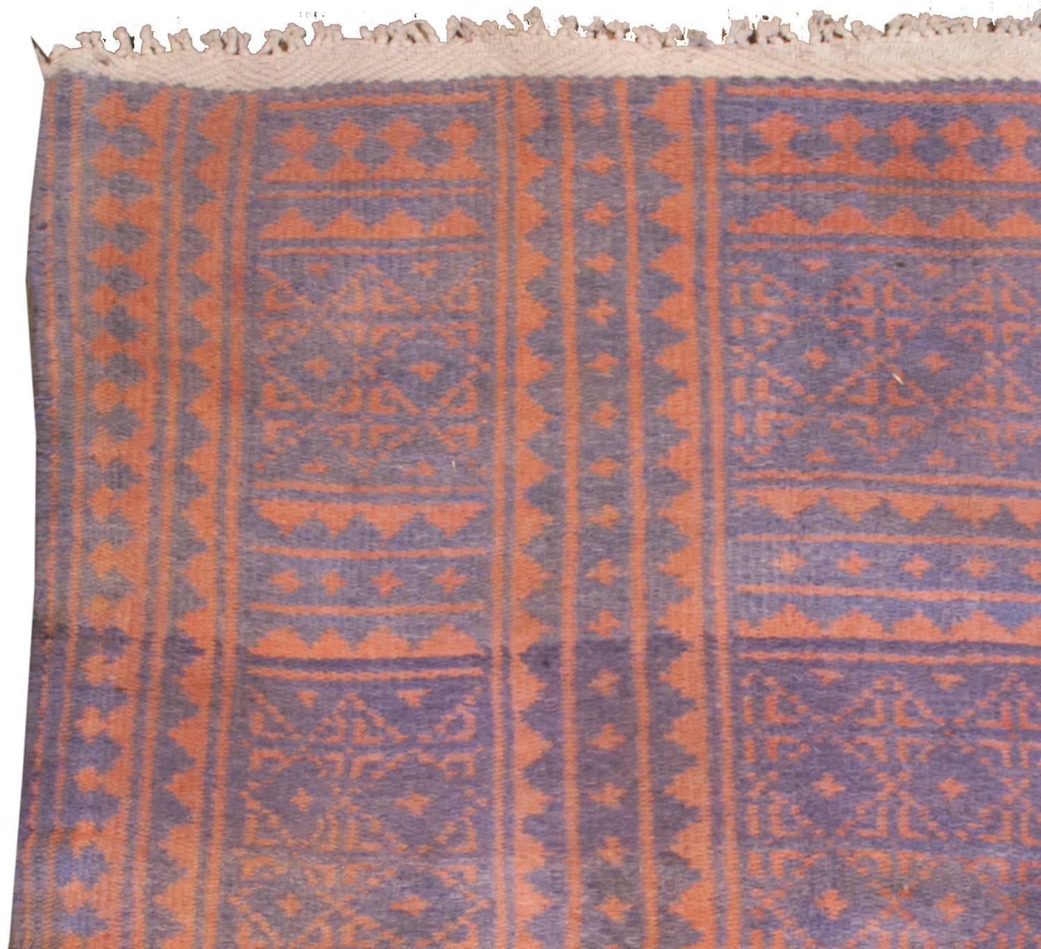 An early 20th century Persian Savek Kilim rug, woven with naturally dyed cotton, with a beautiful all-over field of small-scale geometric pattern of diamonds, crosses, and square dots on an indigo background flanked by a border of geometric zigzag