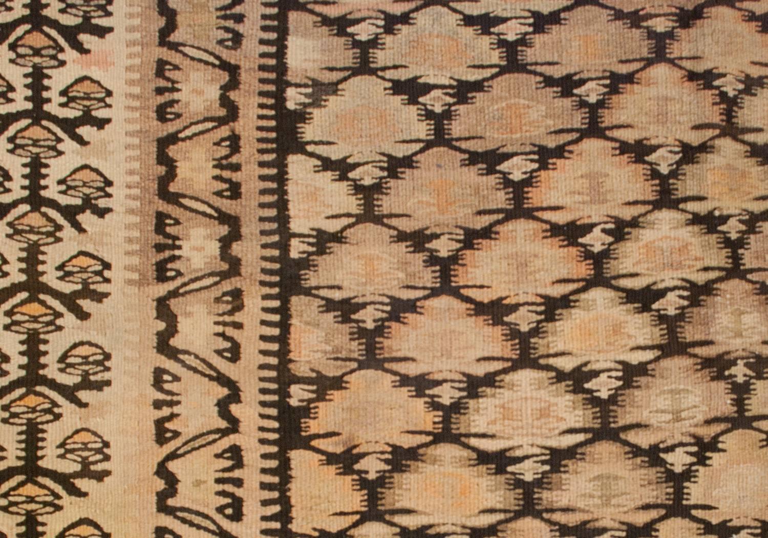 An early 20th century Persian Qazvin Kilim runner with a wonderful all-over stylized tree-of-life pattern on a black background, surrounded by a wide border with contrasting tree-of-life pattern, woven in similar naturally dyed wool.
