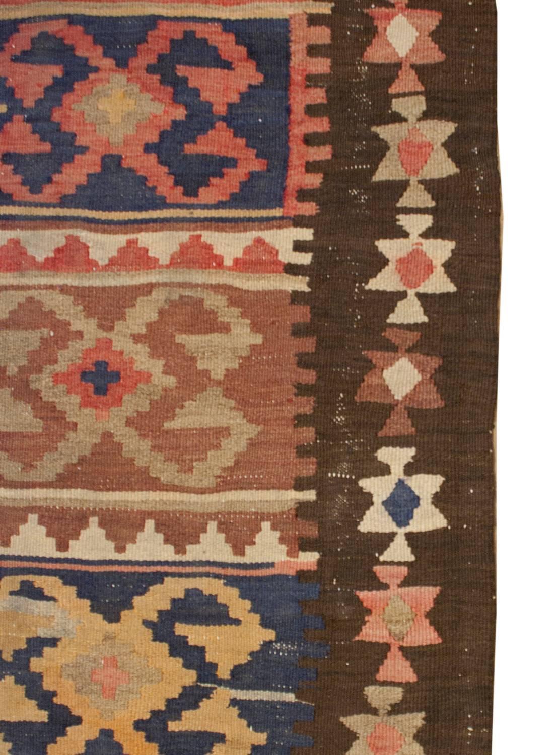 An early 20th century Persian Shahsavan Kilim runner with an incredible motif of geometric forms on multicolored stripes running the length of the runner. The border is simple with multicolored stylized flowers on a black background.