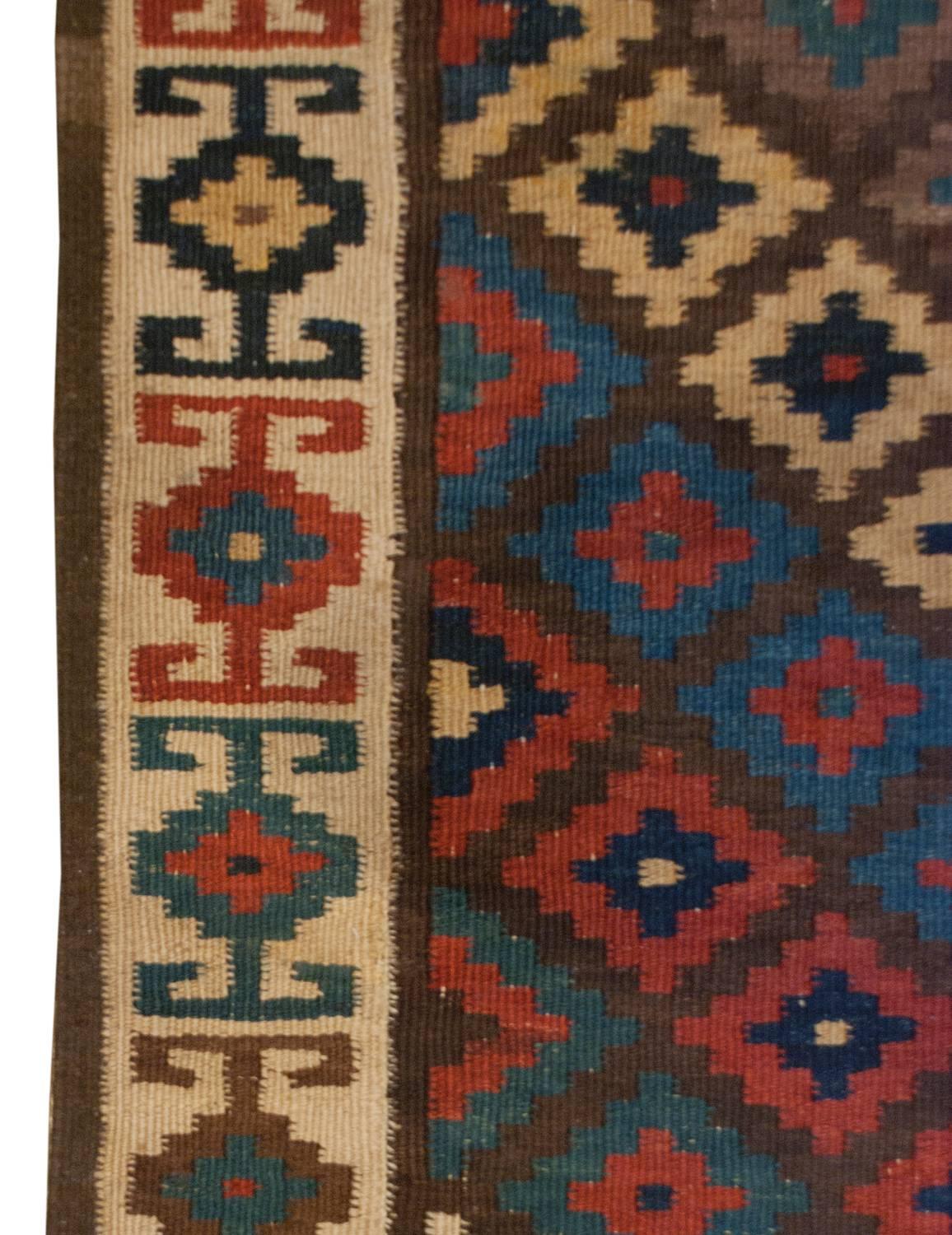 A wonderful early 20th century Persian Saveh Kilim runner with a beautiful central field composed of a multicolored chevron stripe woven in crimson, indigo, green, yellow, white, and brown wool. The border is complementary with a multicolored
