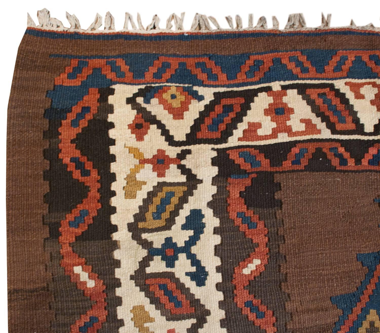 An incredible early 20th century Persian Shahsavan Kilim runner with multiple crimson, indigo and gold diamond shaped medallions running down the center. The border is interesting in that it's pulled away from the actual border of the rug. It's