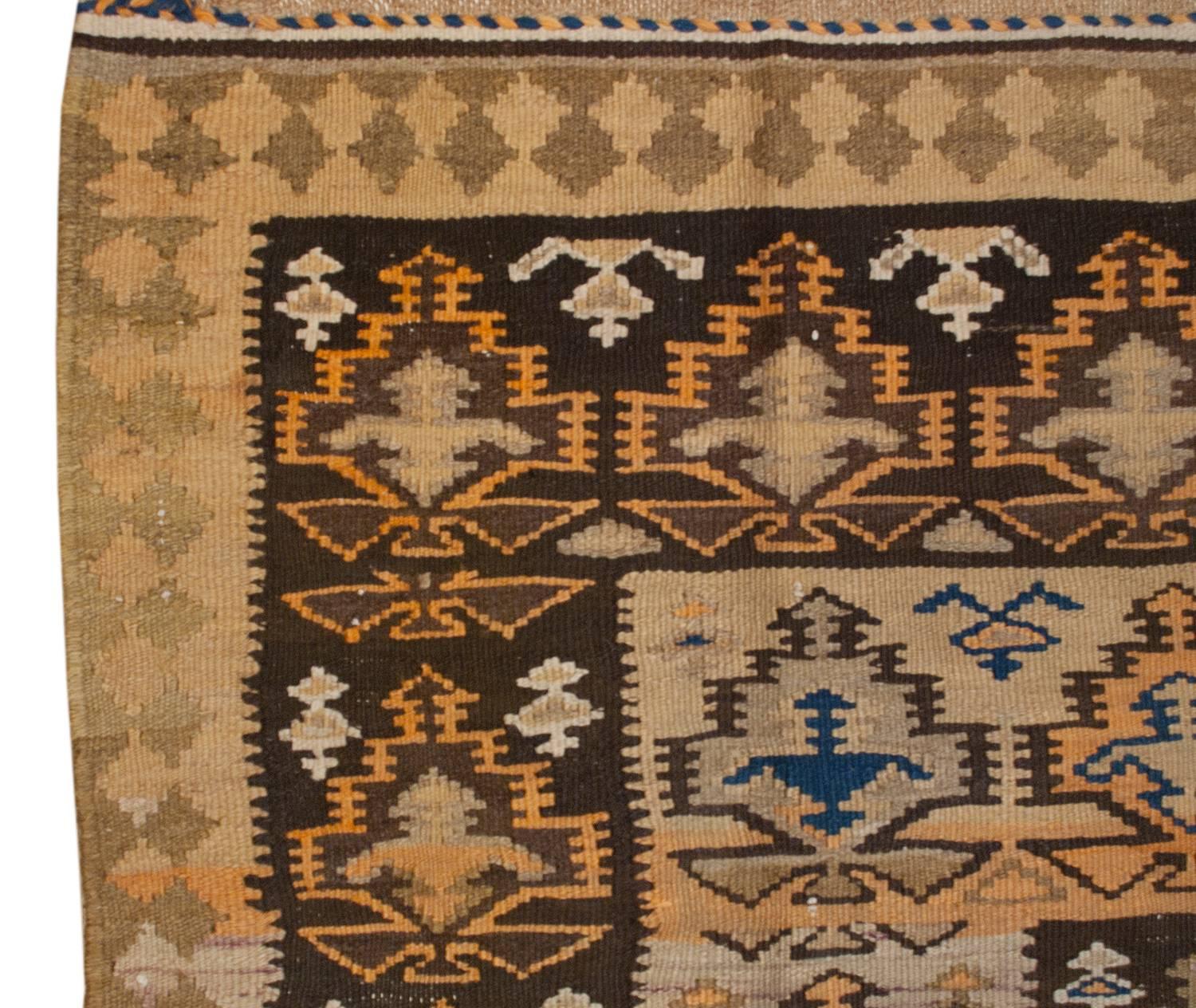A beautiful early 20th century Persian Qazvin Kilim runner with a wonderful pattern of stylized trees-of-life, woven in multi-colored vegetables dyed wool, in a graduated rectangle design. The border is simple, with a tone on tone geometric diamond