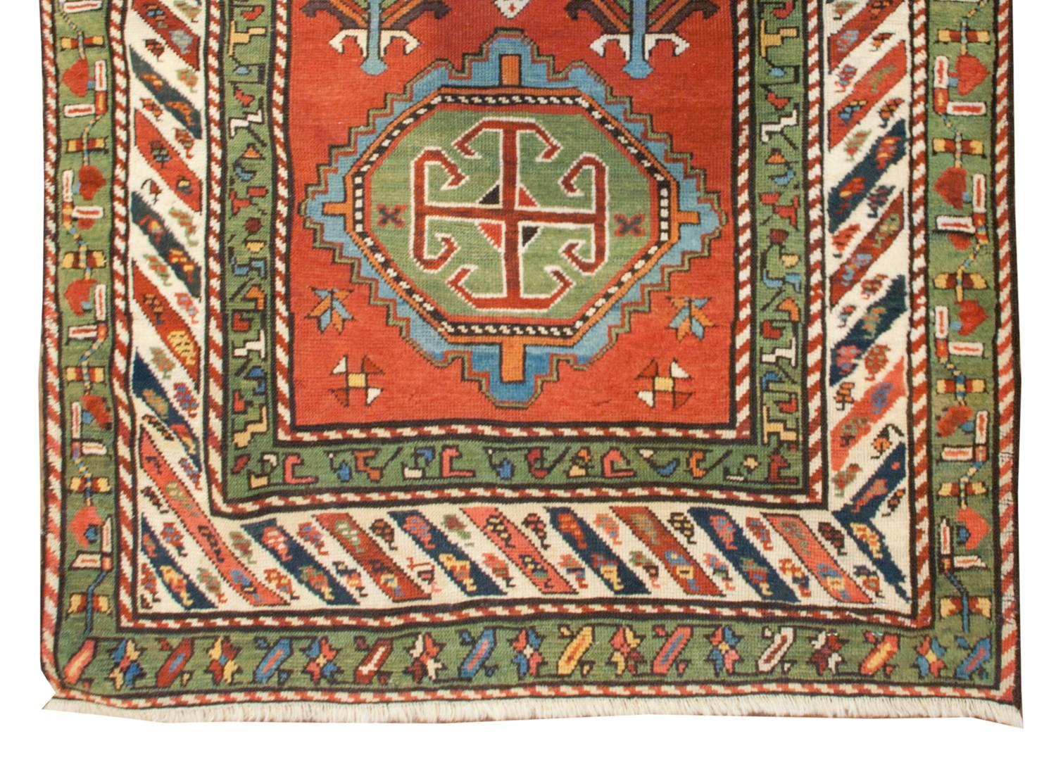An important early 20th century Persian Kazak runner with six wonderful large-scale floral medallions, each woven in a different pattern and color way. Rare pale green dyed wool is prominently featured throughout this rug, which is a unique color