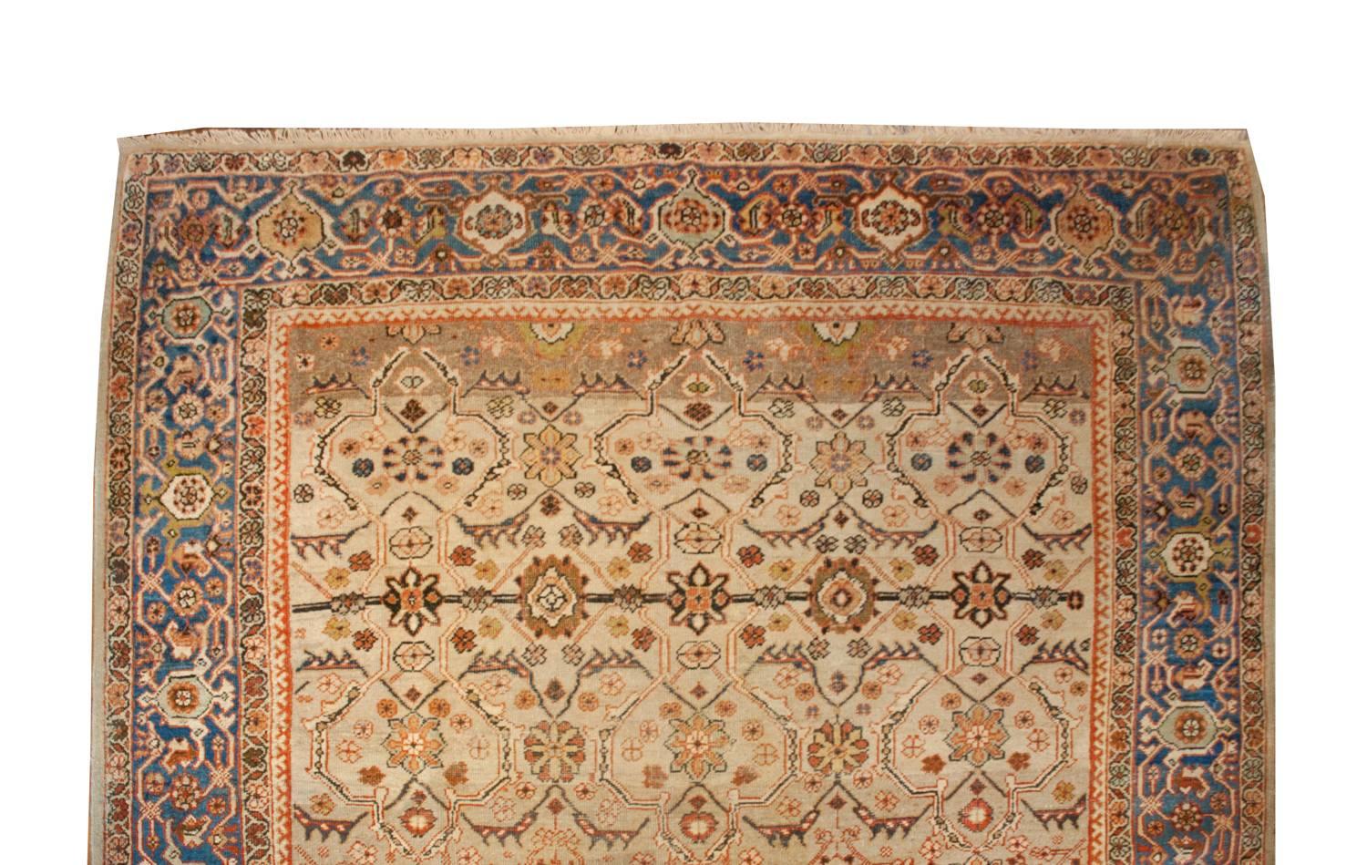 An exquisite early 20th century Persian Mahal rug with a gorgeous lattice-work floral field woven with indigo, crimson, gold and coral vegetable dyed wool, on a natural, undyed, wool background. The border is fantastic with a wide central border