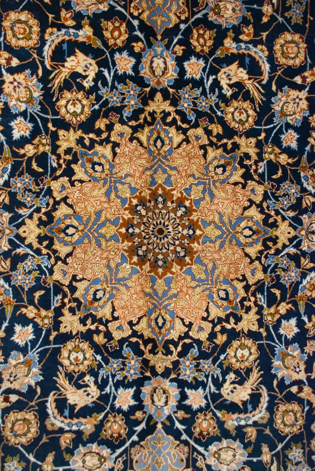 Ein wundervoller, skurriler persischer Isfahan-Teppich aus dem frühen 20. Jahrhundert mit einem faszinierenden, eng gewebten Muster aus bunten Blumen und Ranken auf einem satten indigoblauen Hintergrund. Inmitten des Blumenmusters sind unzählige