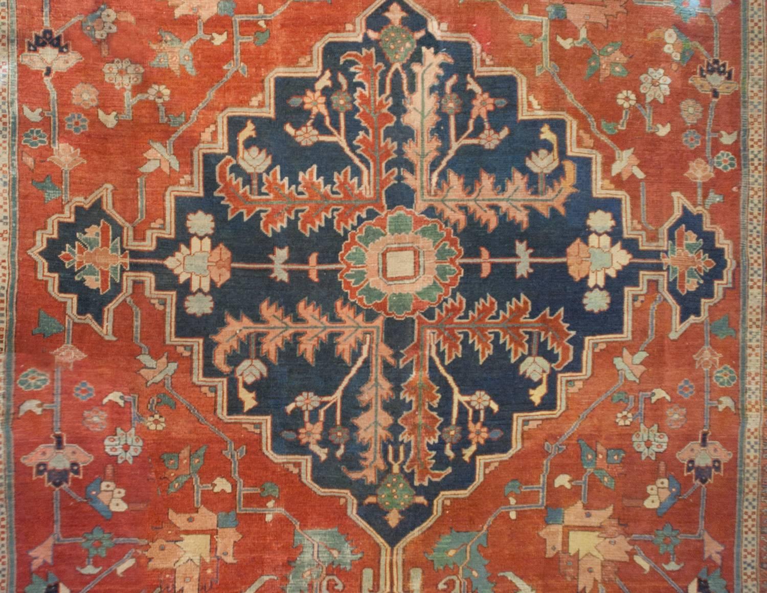 An incredible mid-19th century Persian Serapi rug woven by a highly skilled master weaver! The central medallion is diamond in form with a deep indigo field. In the centre of the field is a large-scale flower with scrolling vines and leaves