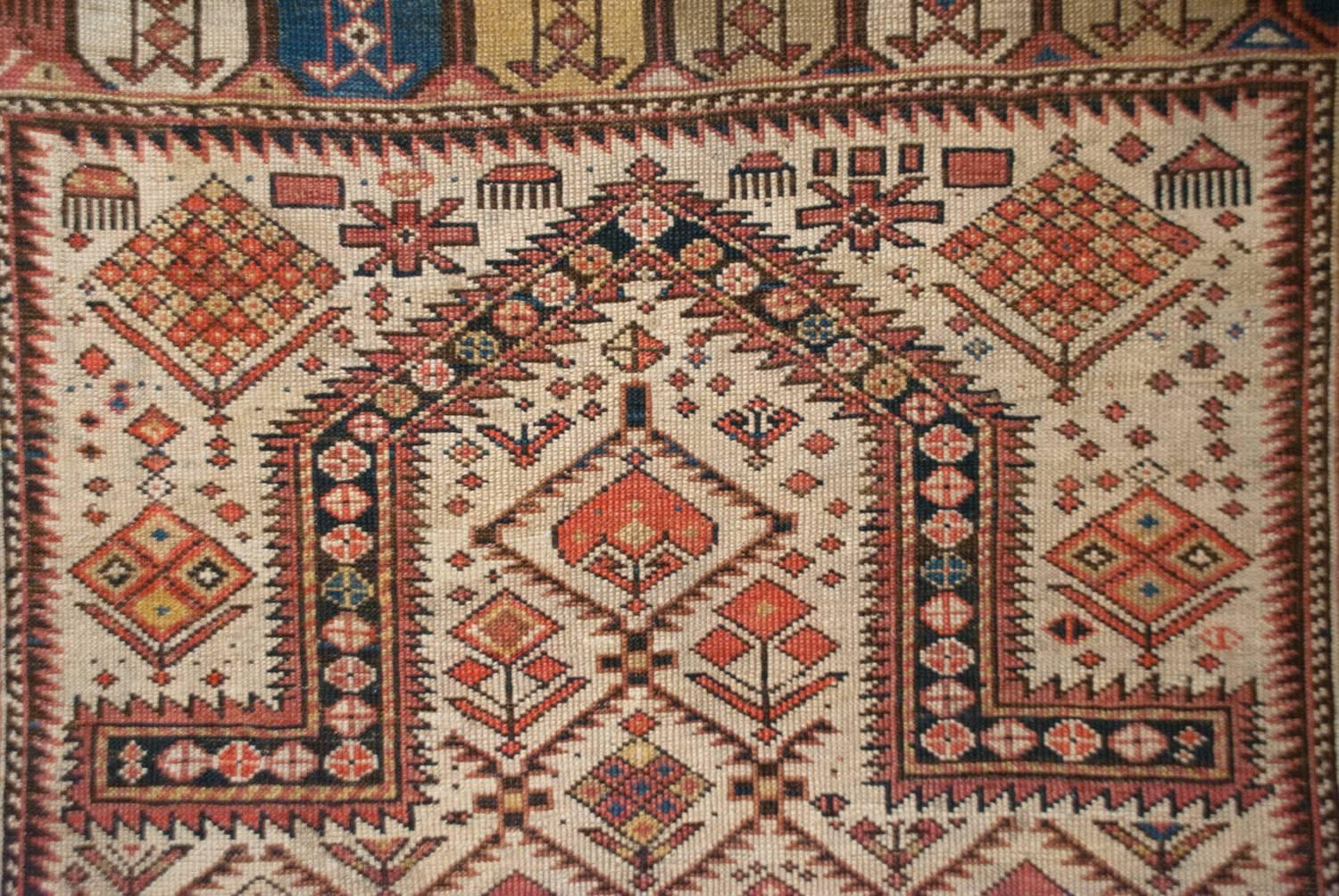 An outstanding mid-19th century Persian Shirvan prayer rug with an incredible stylized multicolored floral pattern field and woven with natural vegetable dyes. The border is exceptional woven with multicolored geometric shapes flanked by petite