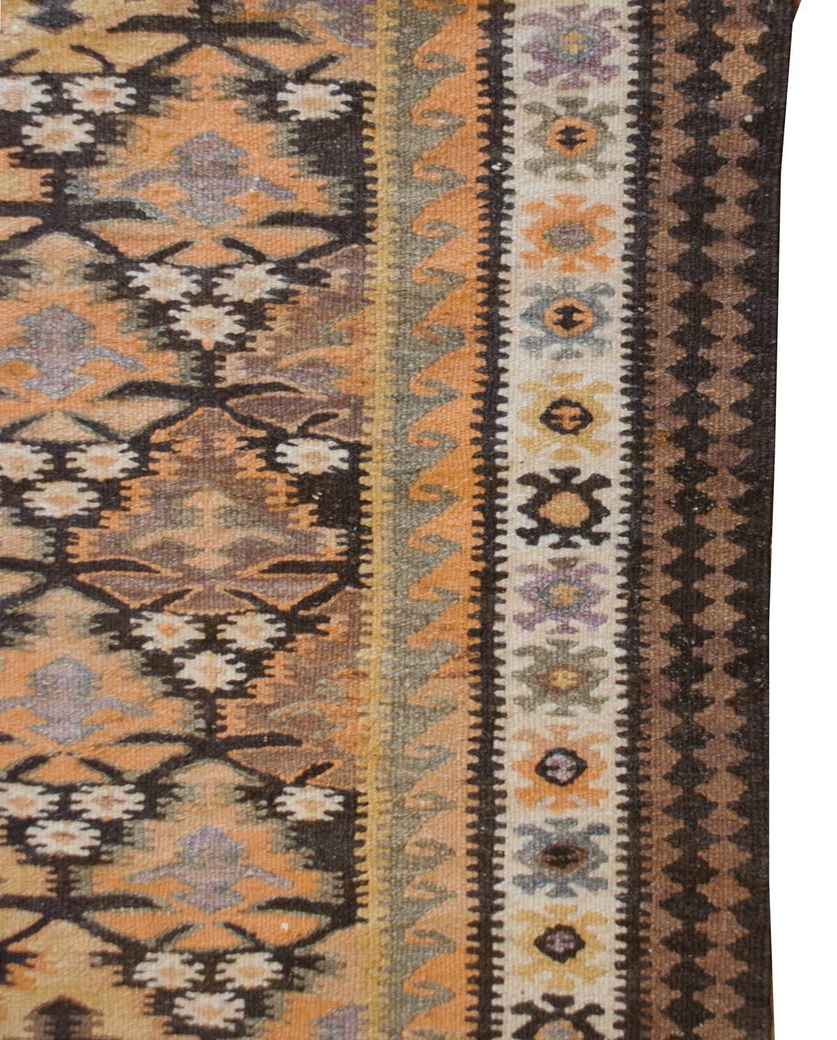 A wonderful early 20th century Persian Qazvin Kilim rug with a beautiful stylized multicolored tree-of-life patterned field woven with incredible natural vegetable dyed wool. The border is exquisite, with alternating zigzag and stylized floral