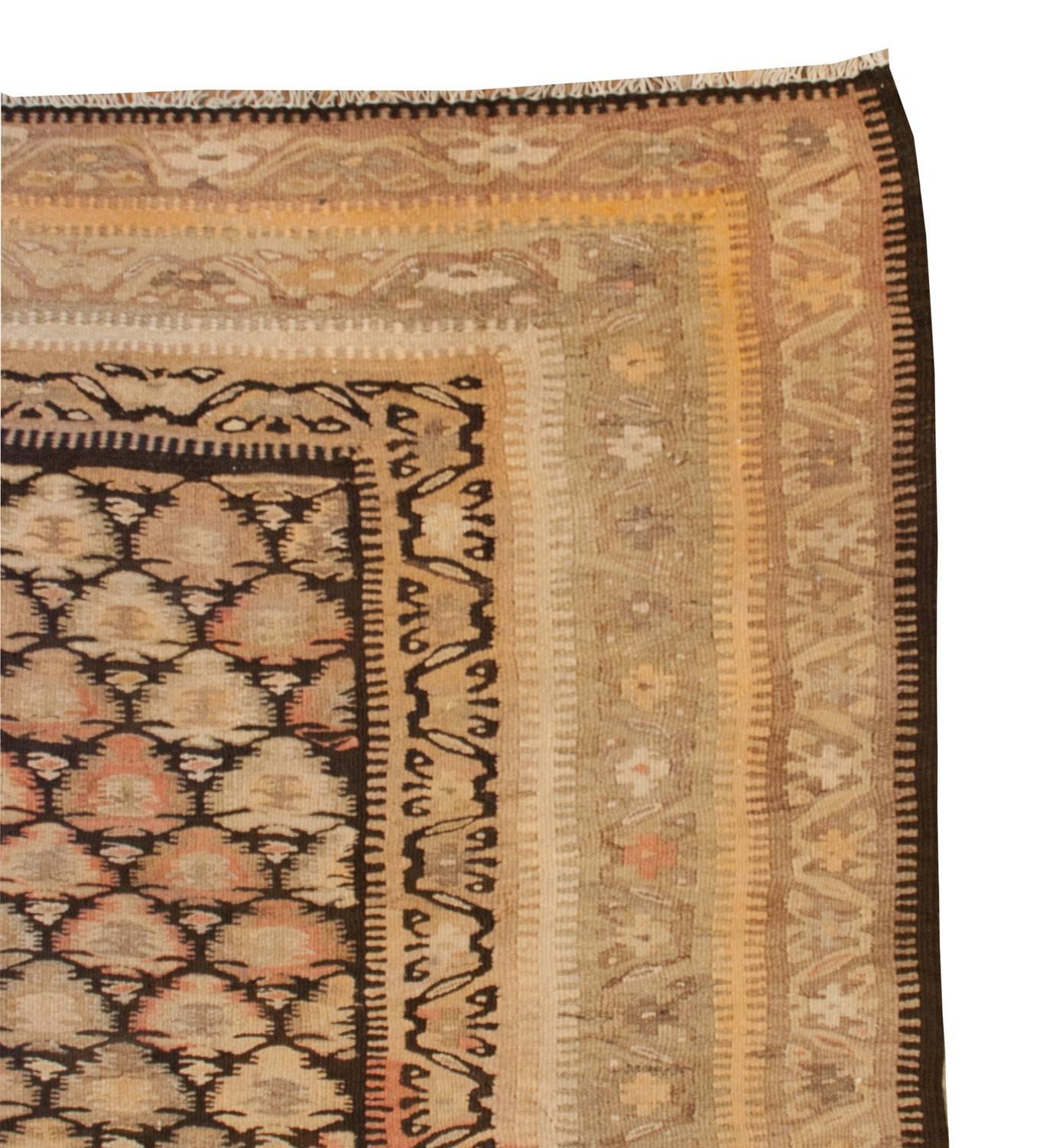 An incredible early 20th century Persian Qazvin Kilim runner with a masterfully woven pattern of stylized tree-of-life patterns woven in natural undid wool and vegetable dyed wool. The border is composed of multiple distinct patterns, each one