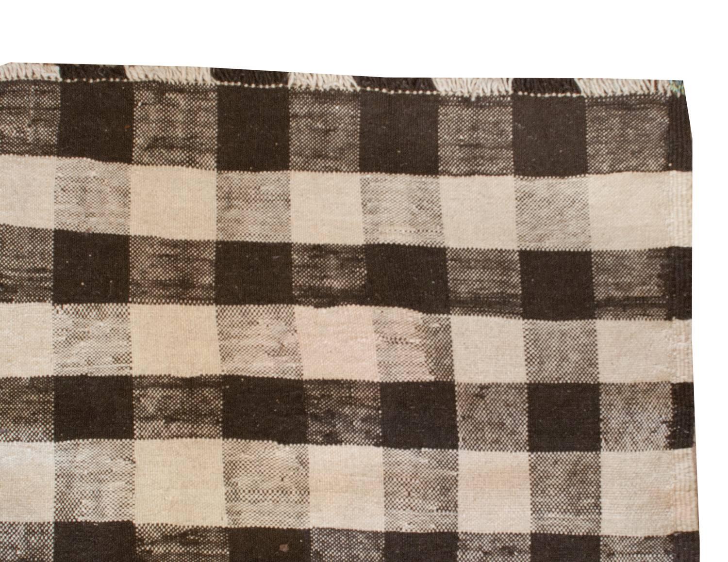 An extraordinary early 20th century Persian Ghashgaei Kilim runner with an unusual woven plaid pattern with natural, undyed, brown and cream colored wool.