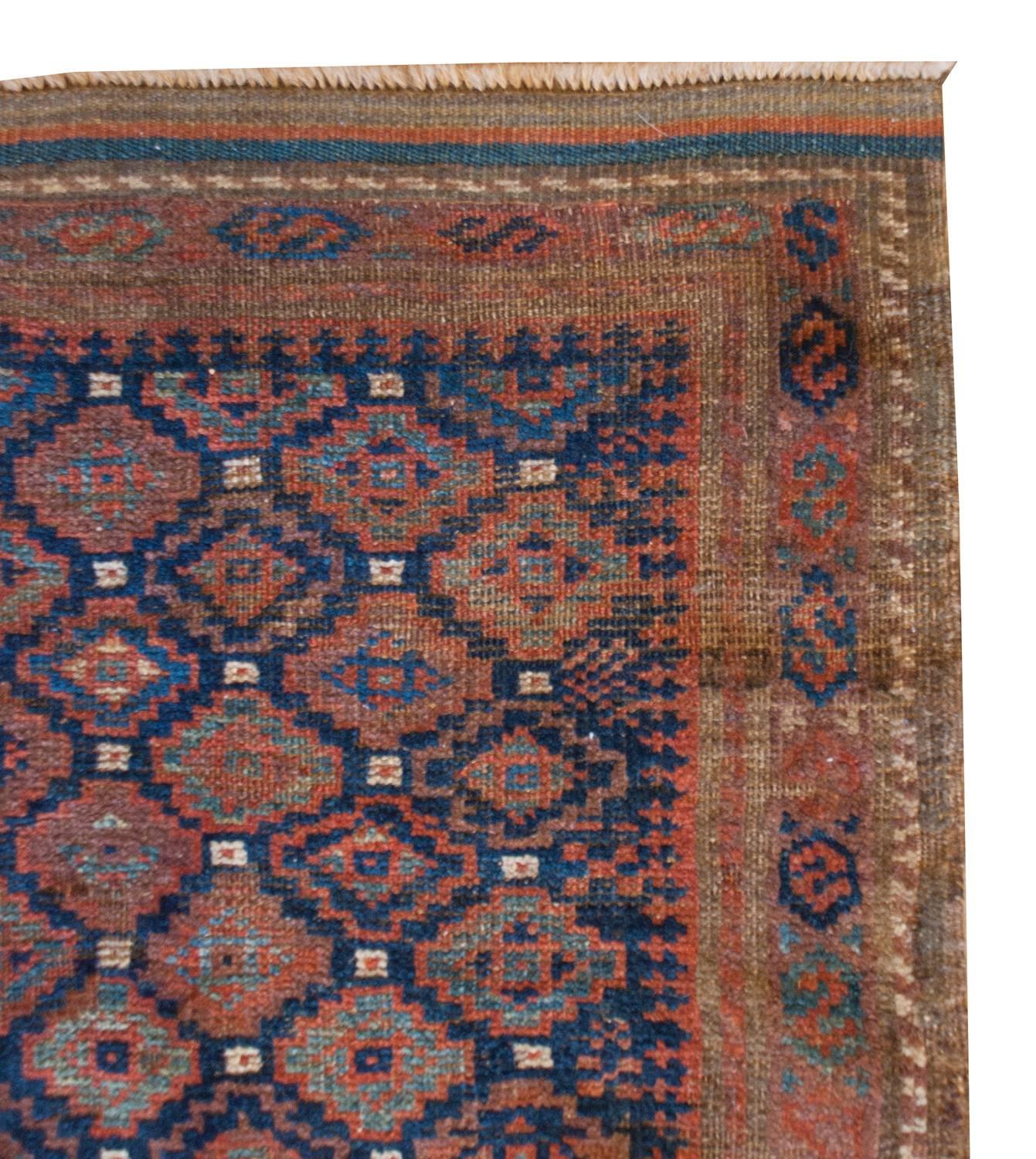 Ein besonderer, zierlicher persischer Belutsch-Teppich aus dem späten 19. Jahrhundert mit einem ganzflächigen, kleinteiligen Rautenmuster, das mit hell- und dunkelindigo- und karminrot gefärbter Wolle gewebt wurde. Die Umrandung ist wunderschön, mit