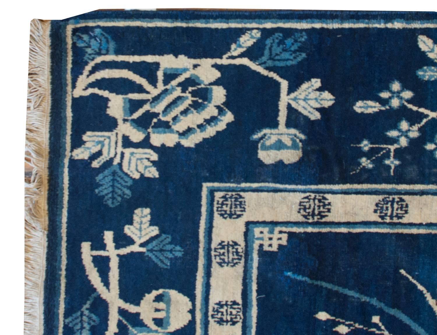 An extremely rare early 20th century pictorial Chinese rug depicting Chinese scholar's objects like potted peonies and chrysanthemums, citron (Buddha's Fingers) with a censor, and a peach, all symbols of longevity and prosperity. The border is