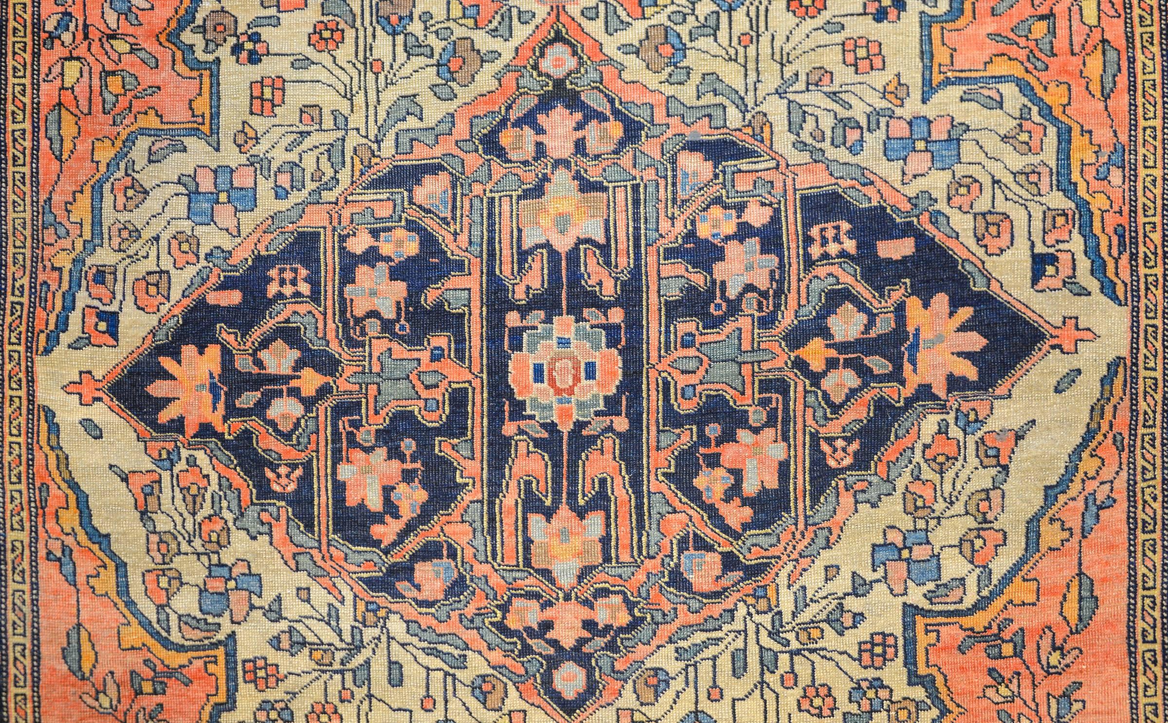 Magnifique tapis persan Sarouk Farahan de la fin du 19e siècle, avec un motif d'une grande densité de vignes, de feuilles et de fleurs entrelacées, tissé avec de la laine teintée à l'indigo, au saumon et à l'or. La bordure est douce, avec un motif