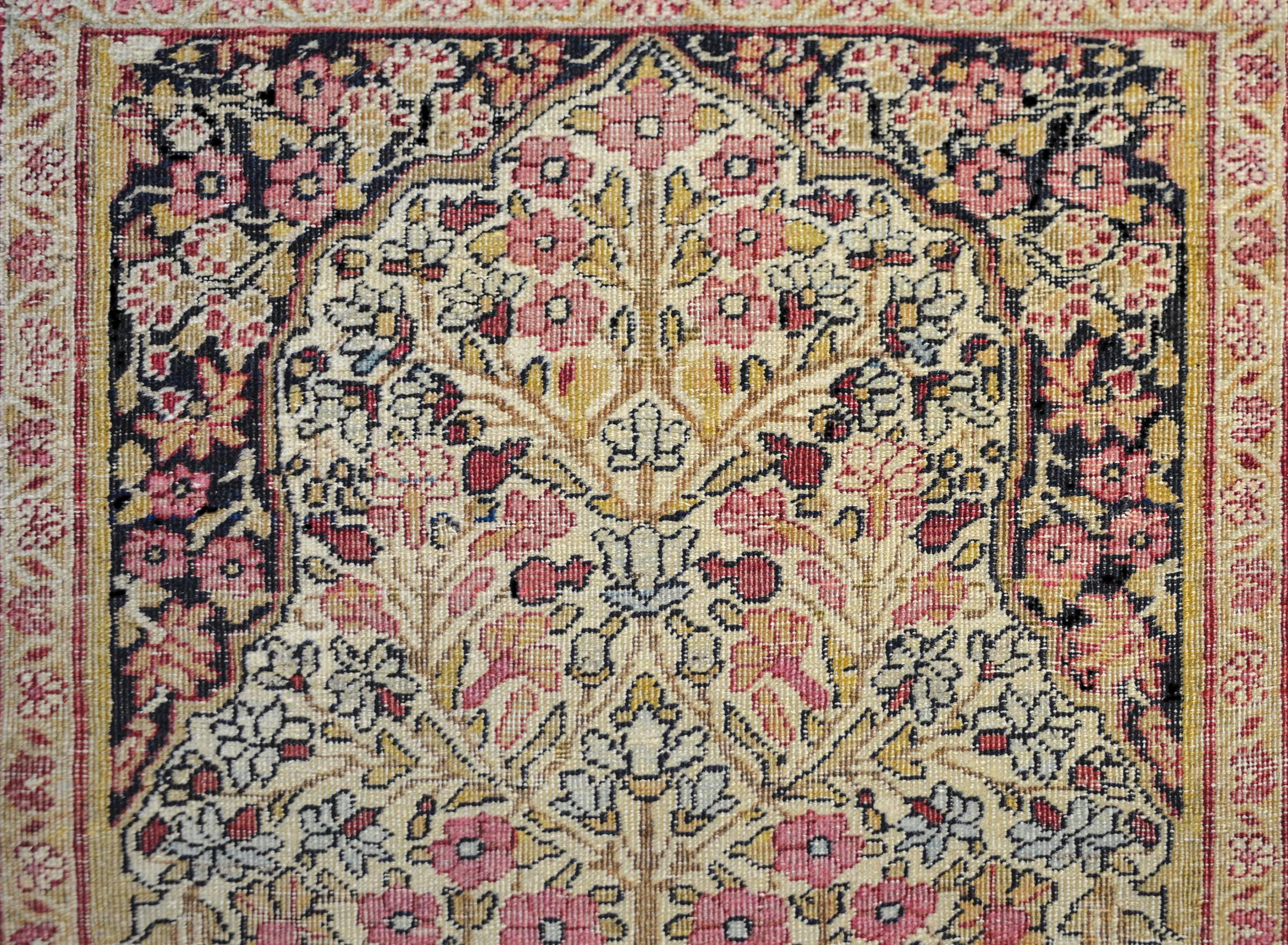 A beautiful late 19th century Persian Lavar Kirman prayer rug with a wonderful densely woven tree-of-life containing myriad variety blossoming flowers amidst a field with a single cypress tree at the bottom. The border is typical, with a densely