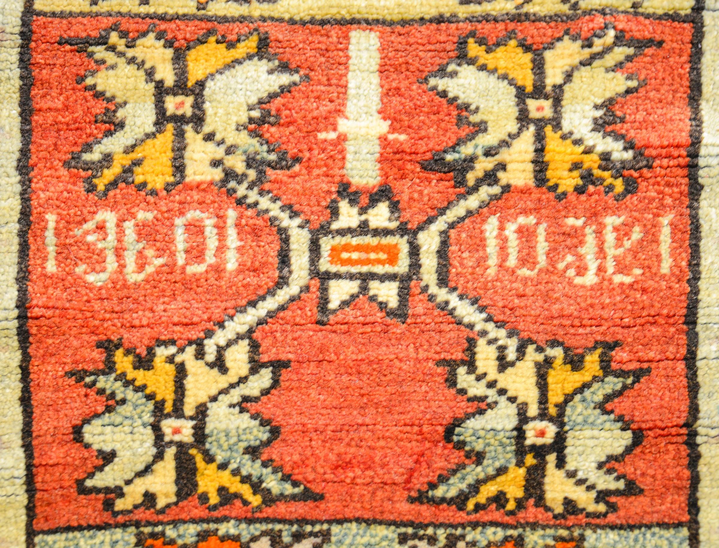 A sweet early 20th century Turkish rug with a three floral sections, one with an indigo background, one with a crimson background, and one with a pale green background. All three have the same floral motif. The border is geometric with multicolored