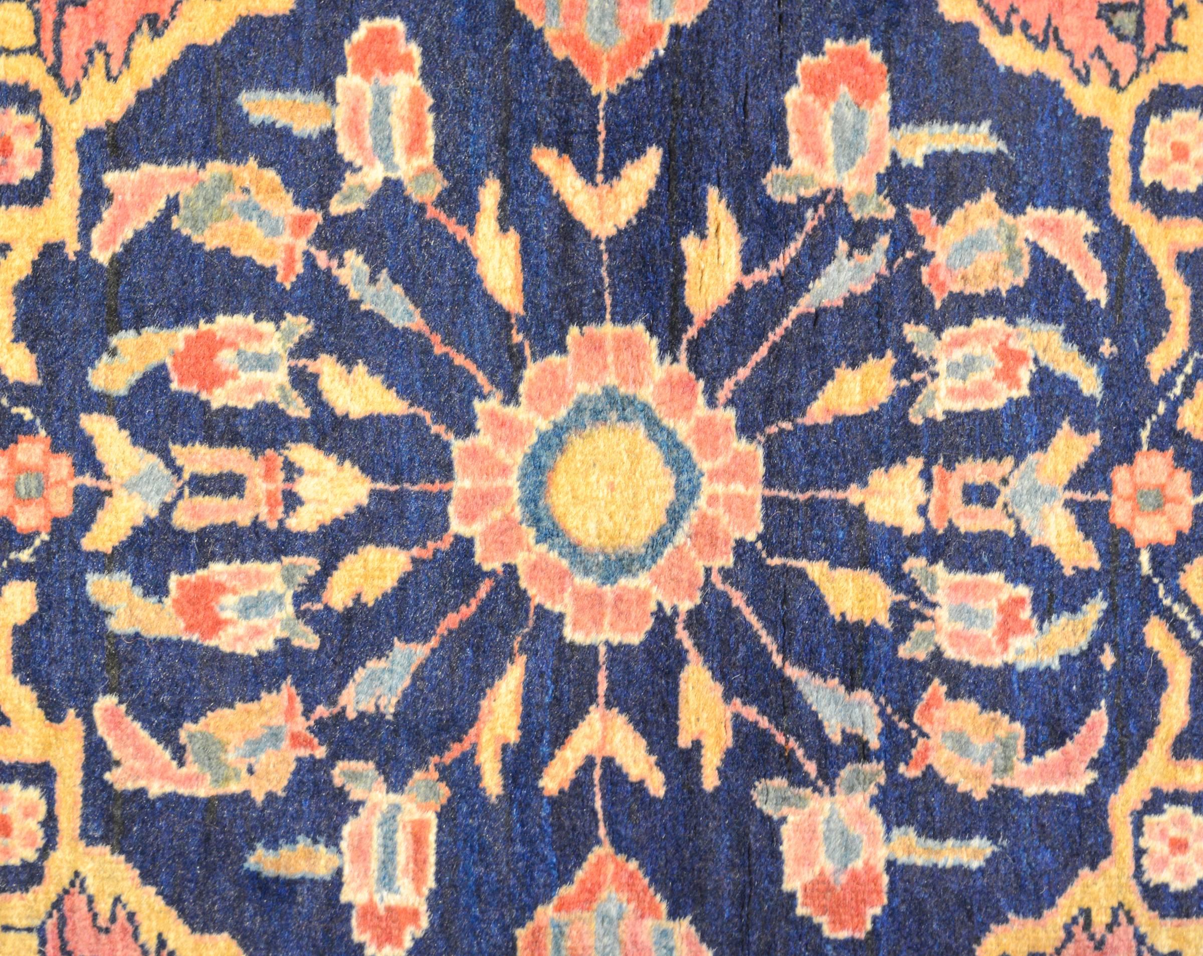 An incredible late 19th century Persian Maharajan rug with a beautifully and skillfully rendered large-scale floral medallion on a indigo background living amidst a salmon field of scrolling vines and flowers. The border is sweet with a large-scale