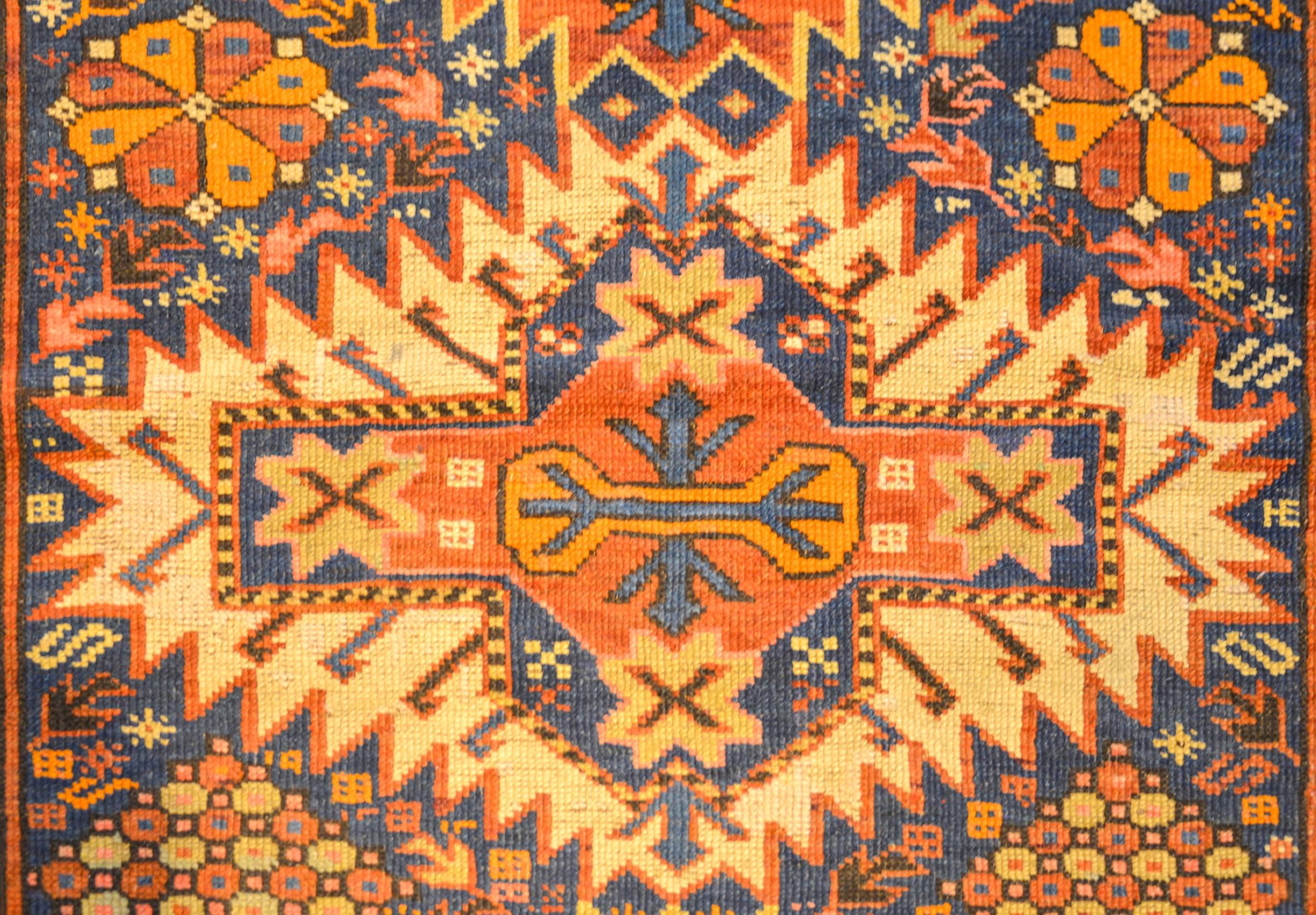 A late 19th century Persian Shriven rug with an incredible bold tribal pattern consisting of three large-scale geometric medallions amidst a field of stylized flowers, on an indigo background. The border is complex with five distinct patterns, each