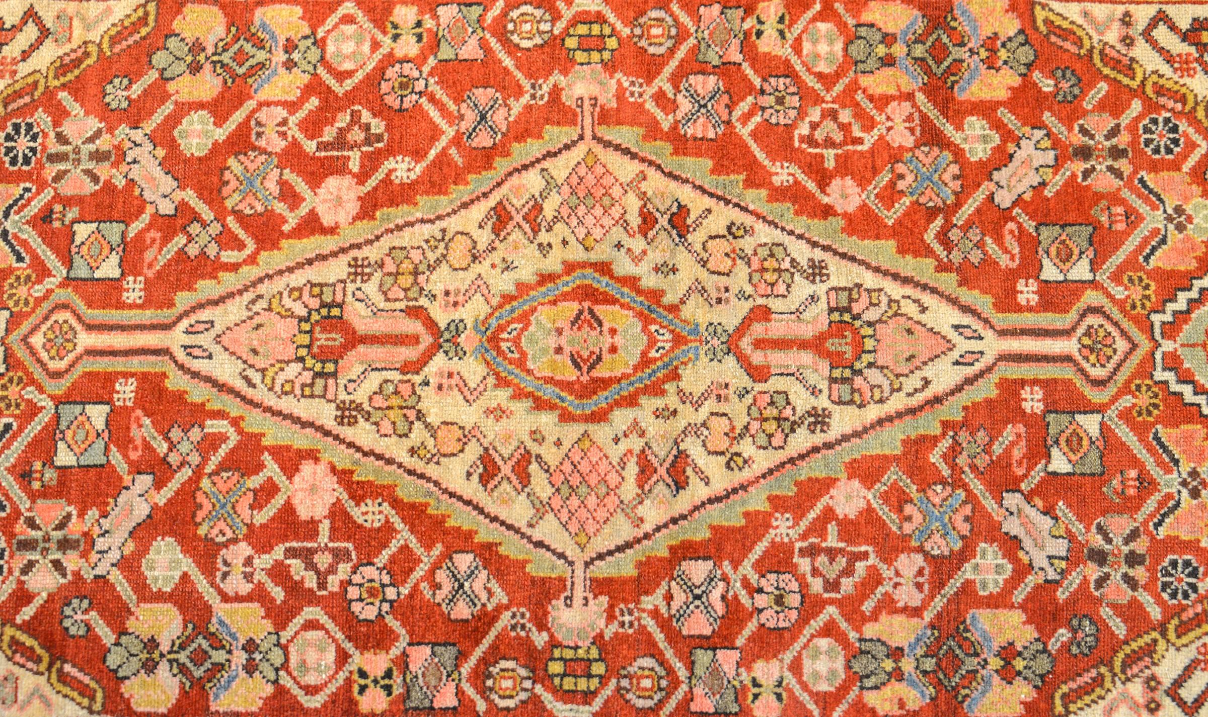 An extraordinary late 19th century Persian Serab rug with an all-over multicolored stylized floral and vine pattern on a crimson background. The flowers are stunning in their, at time, geometric, rendering. The borders is complex consisting of one