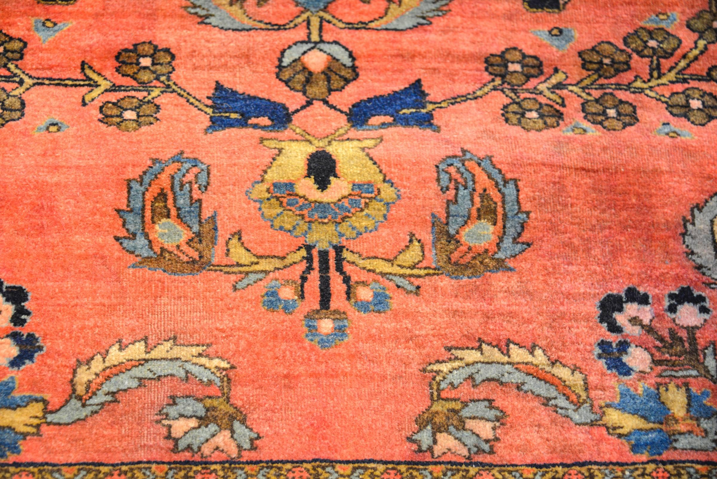 A remarkable early 20th century Persian Sarouk Maharajan with an exquisite all-over mirrored floral and tree-of-life pattern woven in multicolored vegetable dyed wool on a salmon colored background. The border is complex with multiple wide and
