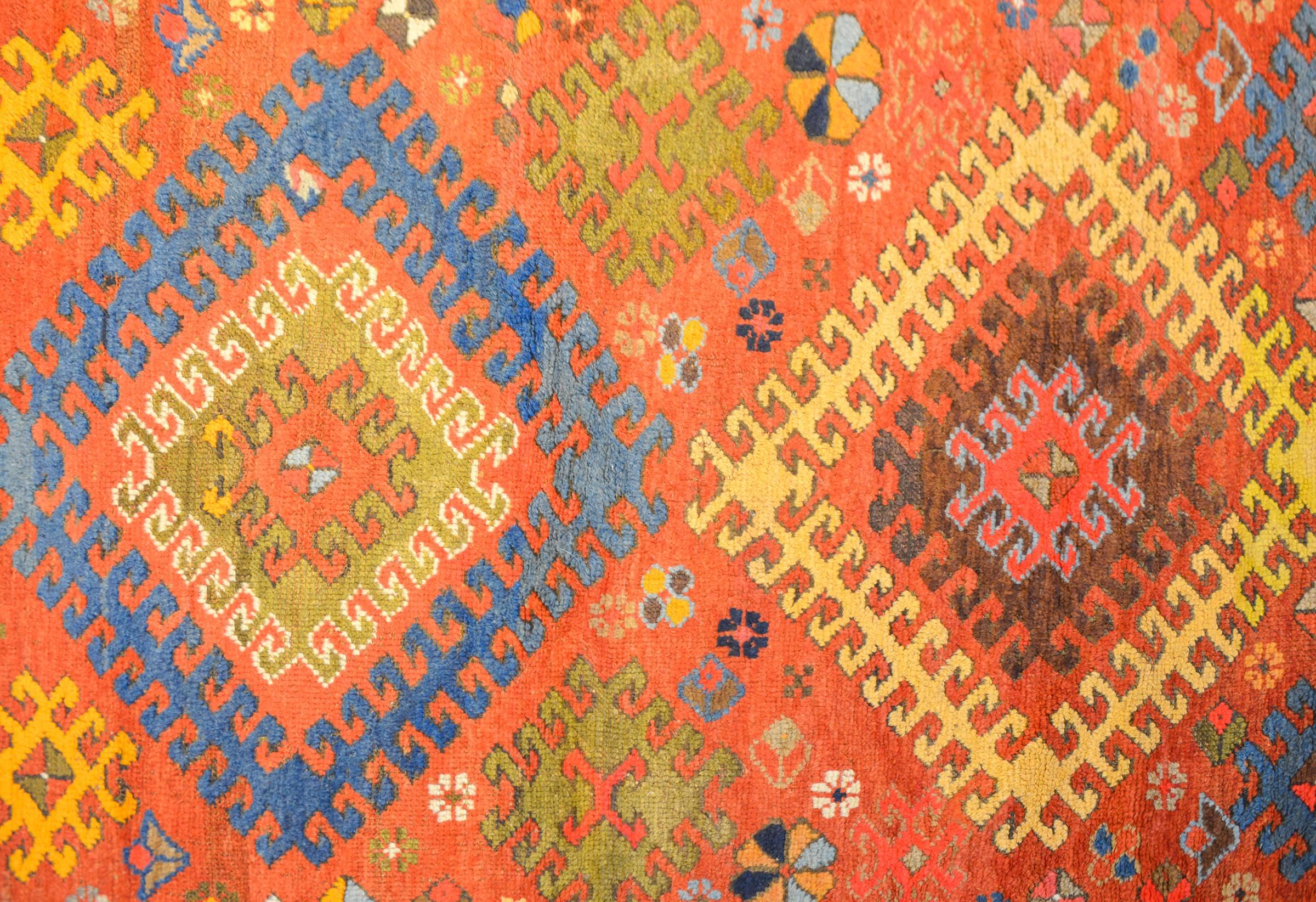 An unbelievable early 20th century Persian Kazak rug with two large geometric medallions, one yellow and one blue, with multiple 